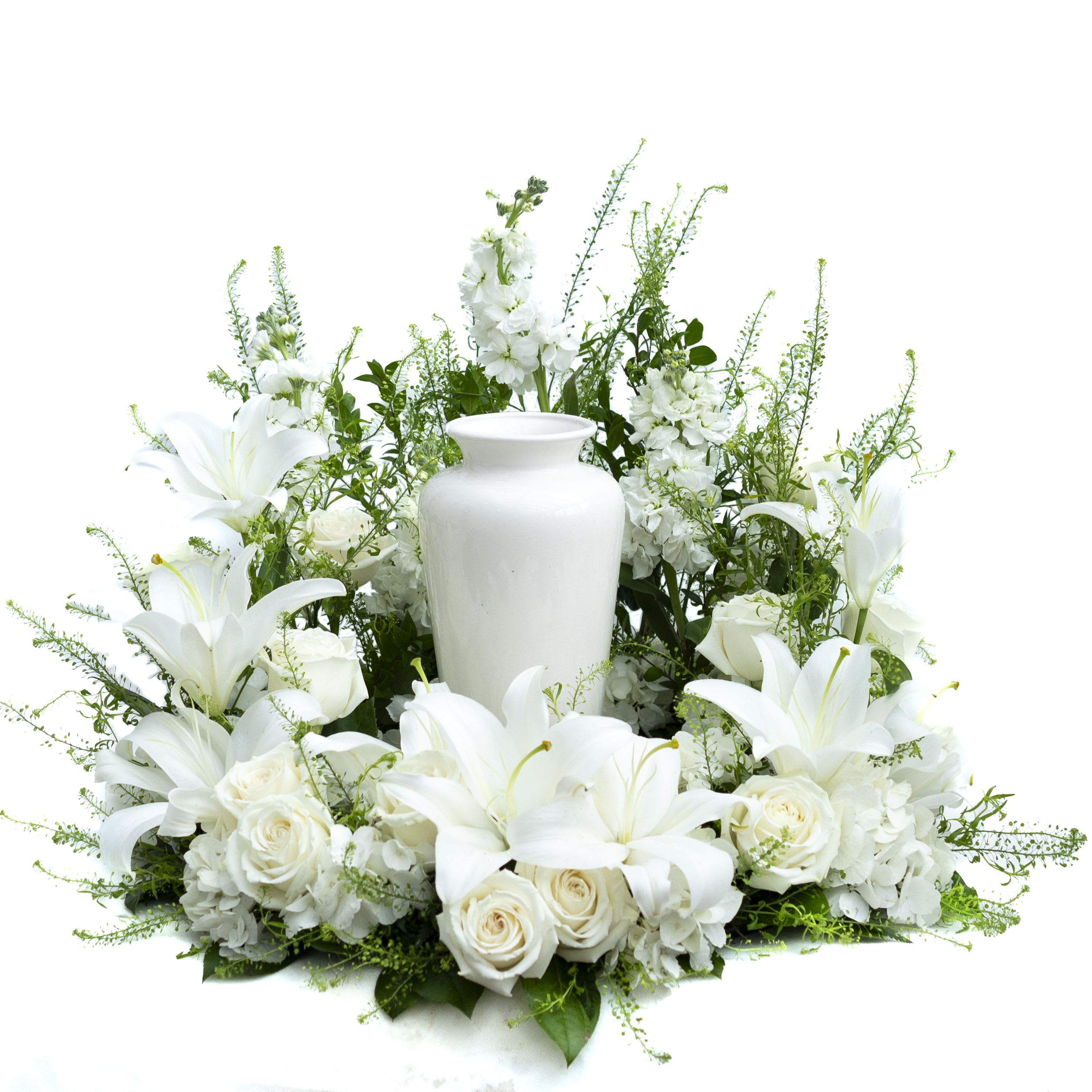 Serenity White Floral Urn Arrangement - Create a beautiful and serene memorial for your loved one with our Serenity White Floral Urn Arrangement. This elegant arrangement features a classic white urn surrounded by a lush display of pristine white lilies, roses, and seasonal greenery. The delicate white flowers symbolize purity and peace, making it a fitting tribute to honor cherished memories. Perfect for funeral services or as a heartfelt gesture of sympathy, this arrangement provides a comforting presence during times of remembrance.