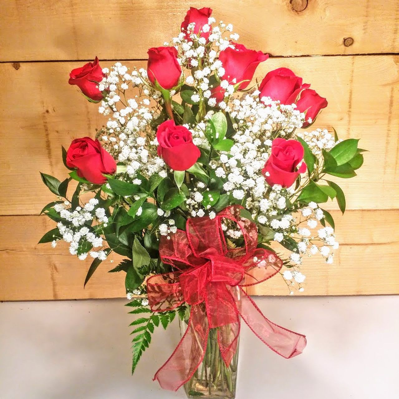 Red Roses Vased Bouquet - Red Roses Vased Bouquet featuring Long-stemmed red roses elegantly displayed in a glass vase. We use only the finest roses available to ensure a spectacular presentation. This version features generous amounts of baby's breath and various popular greens to make an even grander impression.