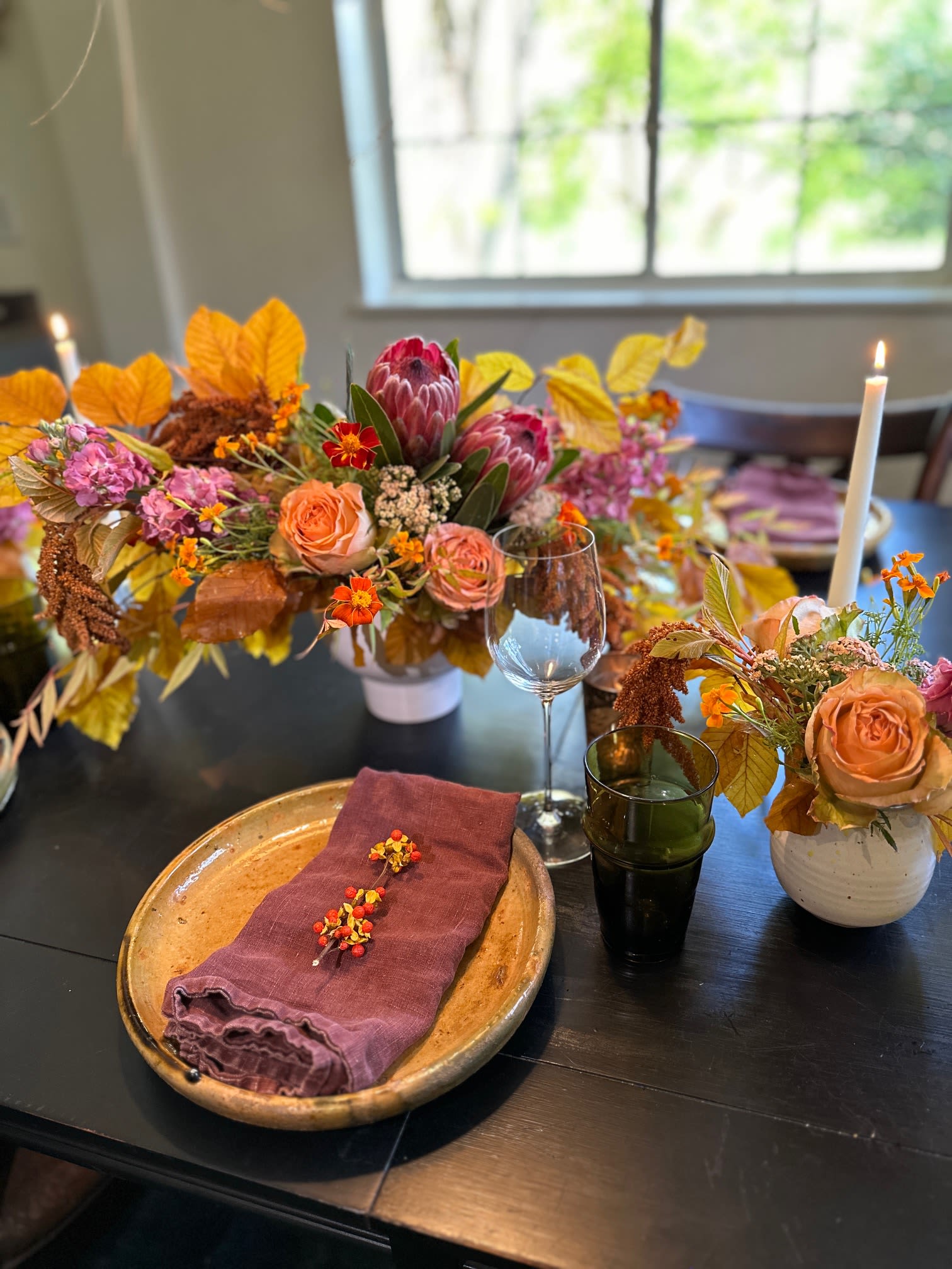 TRIO of Autumnal Centerpieces - Seasonal Designer's Choice - Elevate your autumn decor with this enchanting trio of seasonal centerpieces, each designed to showcase the beauty of fall. A large centerpiece in the center, adorned with rich, jewel-toned foliage, flowers, vines and branches. Then 2 smaller arrangement on either side, to create a beautiful, fall tablescape, or to add extra color somewhere else in your home. Together, these three centerpieces celebrate the spirit of the season, adding warmth and charm to your home, whether for a festive gathering or a quiet evening in.