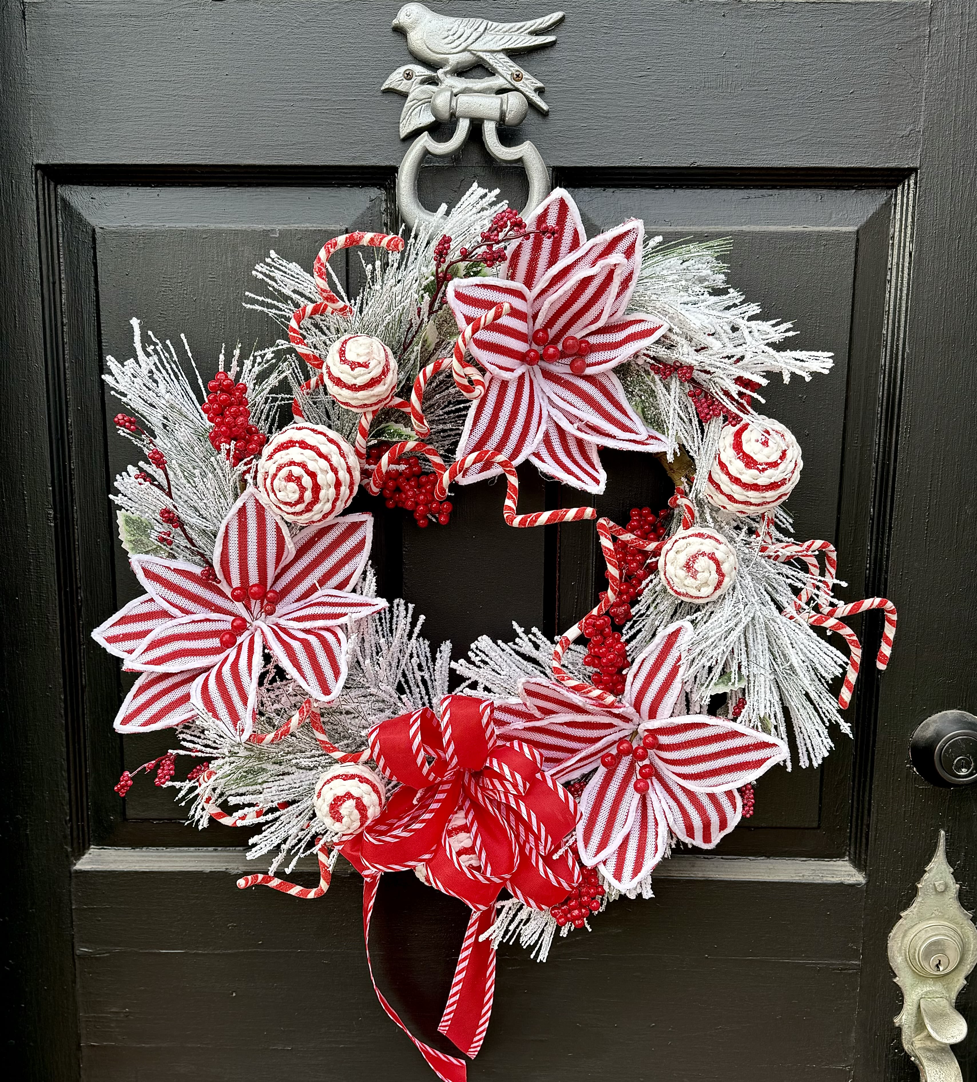 Festive Holiday Wreath  - A fun white flocked wreath, with peppermint striped poinsettia flowers, ornaments, and berries! 