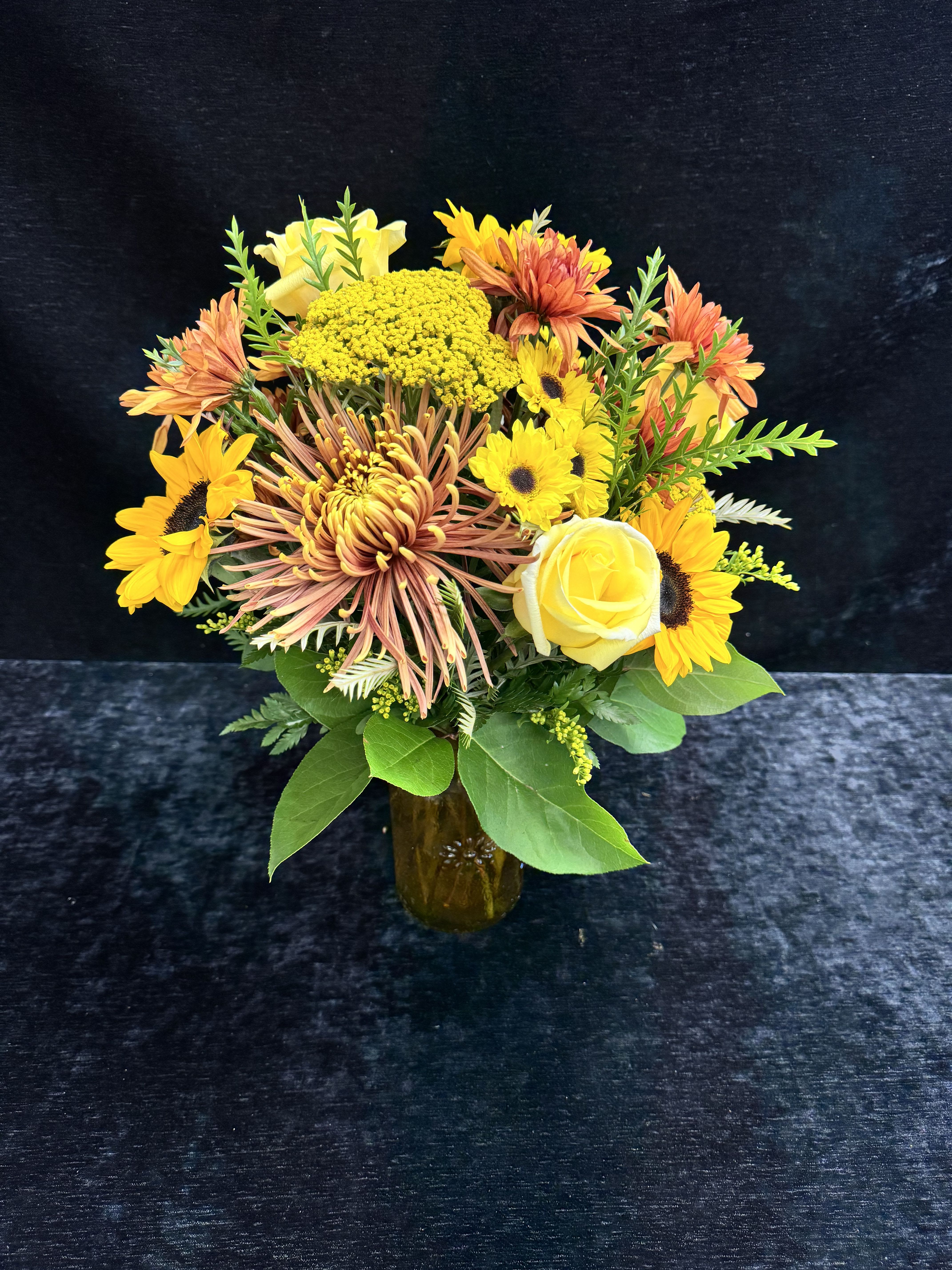 Golden Hour - Beautiful Golden tones combine to make a bright autumn addition for any occasion! Includes Sunflowers, Roses, Mums, Poms, and Yarrow.