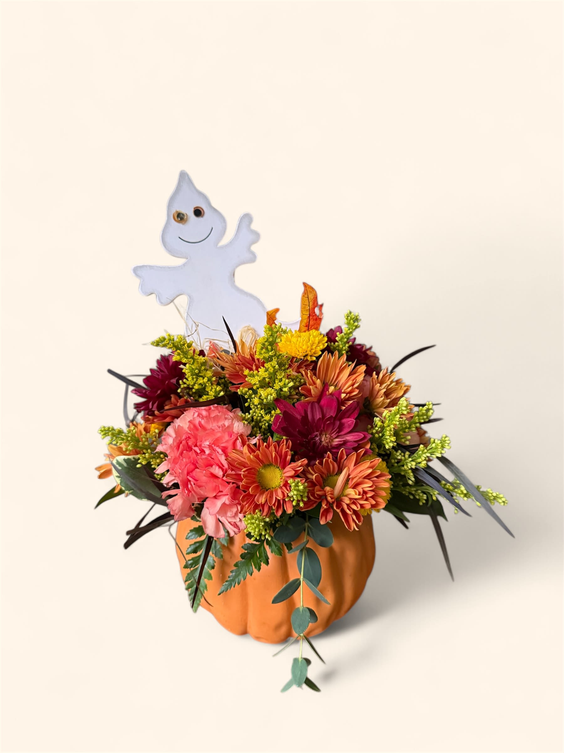 Boo-tiful Blooms - This playful arrangement features bright fall flowers in a pumpkin container, topped with a friendly ghost for a touch of spooky fun. Perfect for parties, gifts, or festive décor.