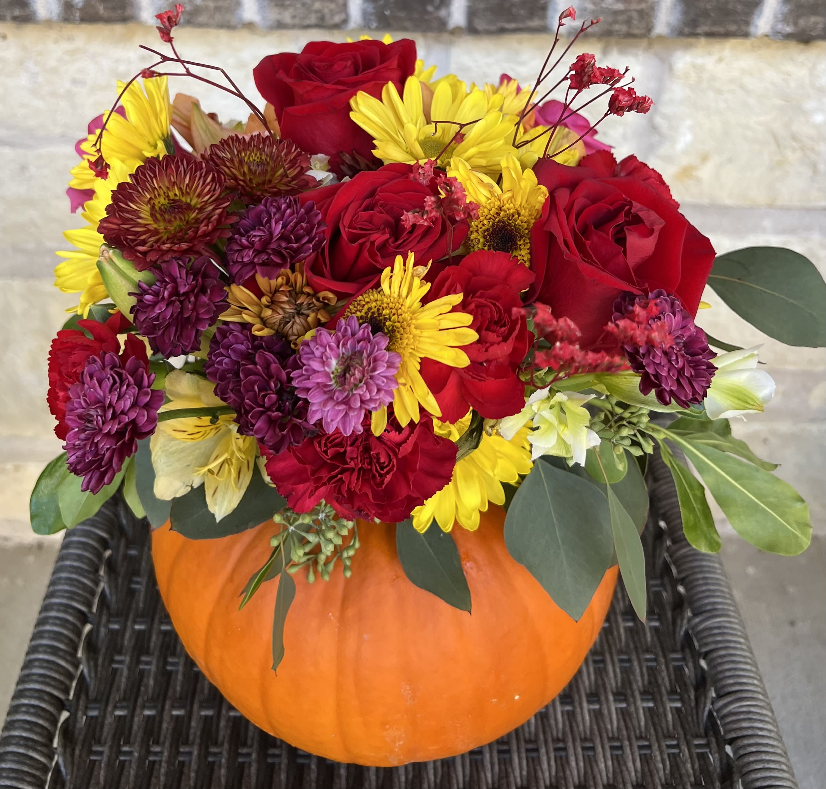 Pumpkin Spice - Mixed fall flowers on top of a fresh pumpkin.