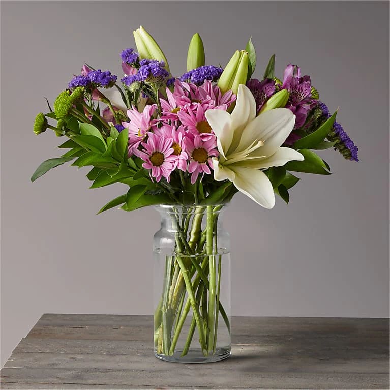 Lilac Gardens - Picked fresh from the farm, theLilac Gardens Bouquet is set to send your warmest greetings to friends and family near and far. This arrangement features a soft array of enchanting colors, including lavender, purple, and white, great for any occasion or just because.