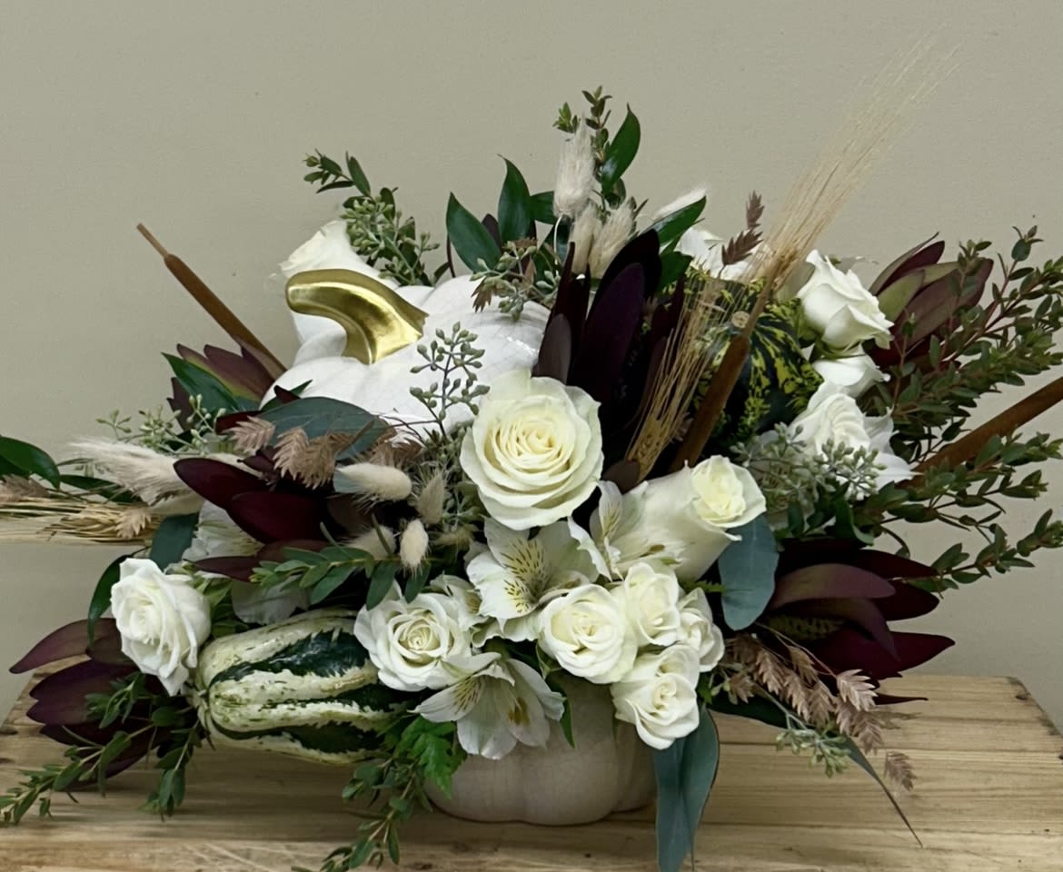 White pumpkin arrangement - White roses, burgundy flowers, and mixed greens in a white pumpkin