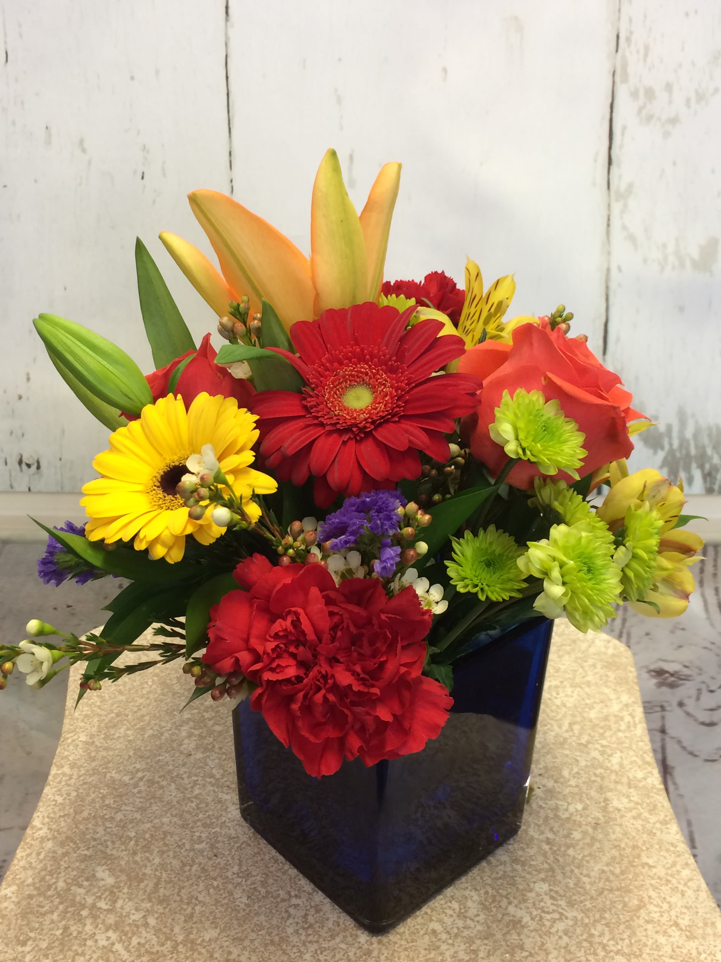 Modern Love - A modern cobalt blue cube designed with bright primary blossoms - A bold statement of expression in reds, oranges, yellow and green accents