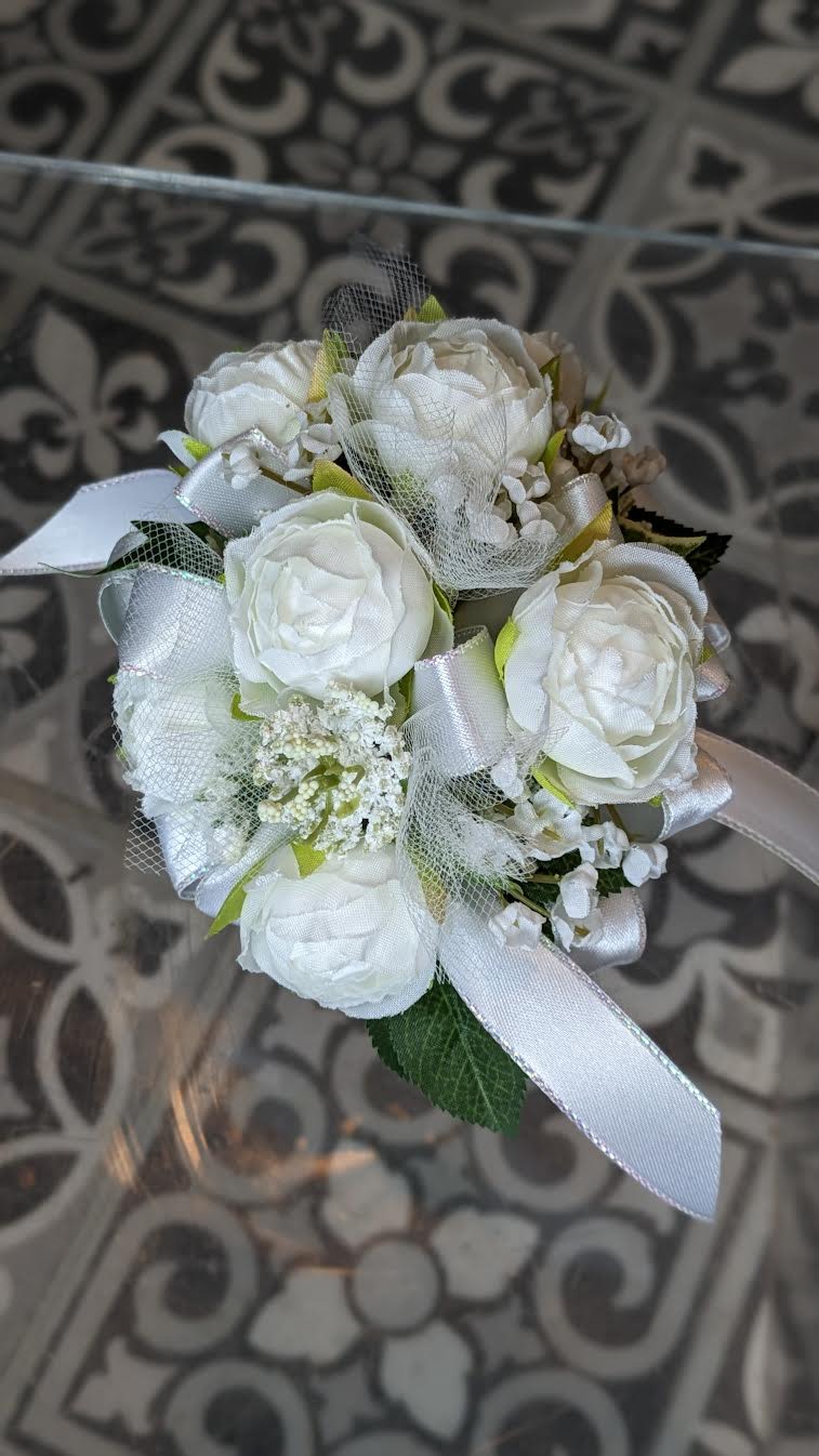 White Whisper Silk Wrist Corsage - These are artificial flowers. The flowers and ribbon cannot be changed. It is currently on a white snap band but can be put on a black, silver or gold snap band if needed, if they are available.