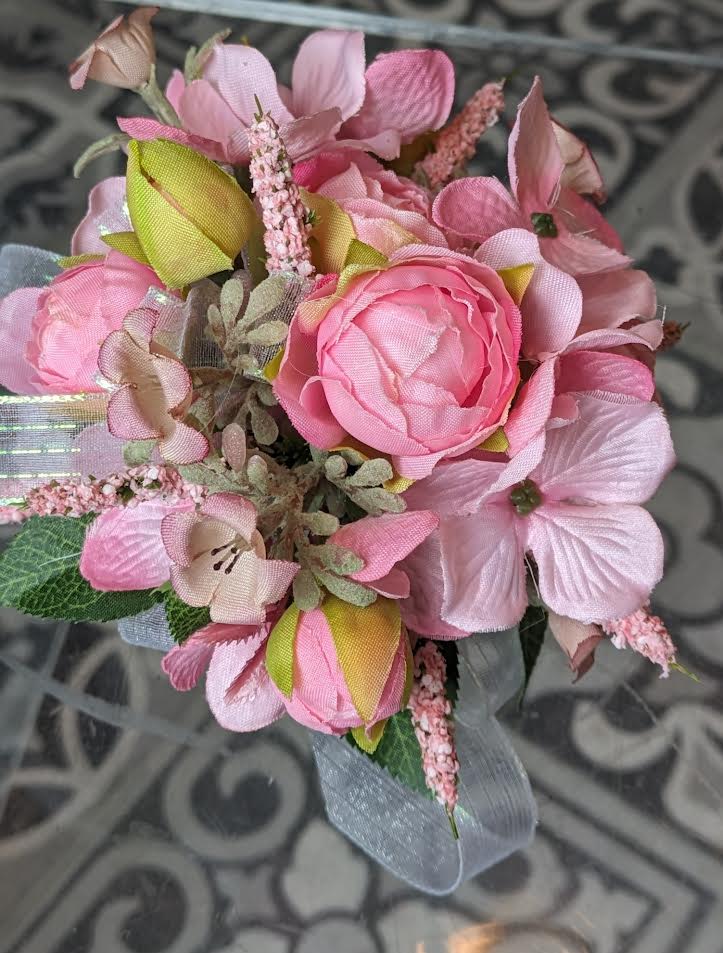 Perfectly Pink Silk Wrist Corsage - These are artificial flowers. The flowers and ribbon cannot be changed. It is currently on a white snap band but can be put on a black, silver or gold snap band if needed, if they are available.