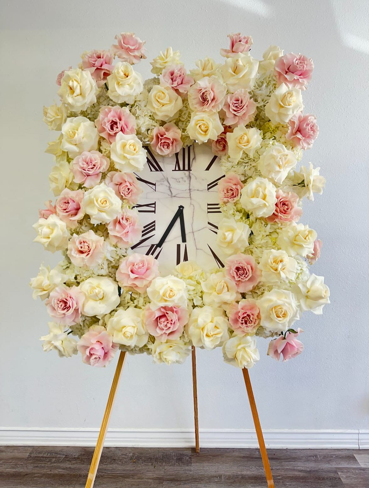 Eternal Time - An elegant floral clock tribute, designed with lush ivory and blush roses accented with soft greenery. The clock at the center symbolizes the passage of time, eternal love, and cherished memories. A heartfelt and artistic arrangement, perfect for funerals, memorials, or religious ceremonies where symbolism holds deep meaning.