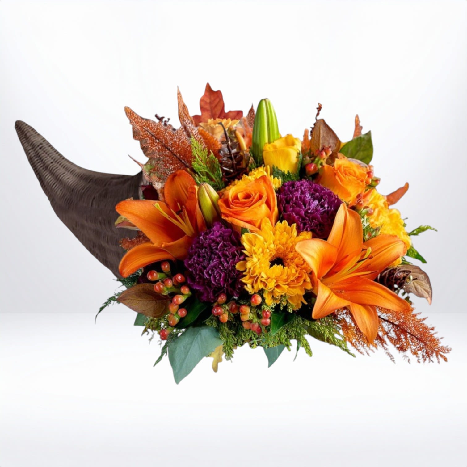 Autumn Radiance Cornucopia - The Autumn Radiance Cornucopia bursts with vibrant fall color — bold orange lilies, golden roses, deep plum carnations, and fiery chrysanthemums create a lush, layered display. Accented with seasonal textures and berries, this design makes a stunning centerpiece for Thanksgiving feasts or fall celebrations.  Available for same-day flower delivery in Galveston, Houston, and surrounding areas, this arrangement brings warmth and color to every holiday table.  Substitution Disclaimer: Due to seasonal availability, some blooms may be replaced with similar varieties of equal or greater value to maintain the design’s look and integrity. Your arrangement will always reflect the same spirit, palette, and premium quality.