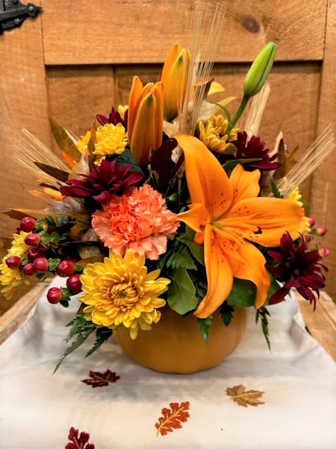 Giving Thanks Pumpkin - Give Thanks this holiday season with the perfect pumpkin Thanksgiving centerpiece filled with lilies, mums, carnations, berries and sprays of wheat.