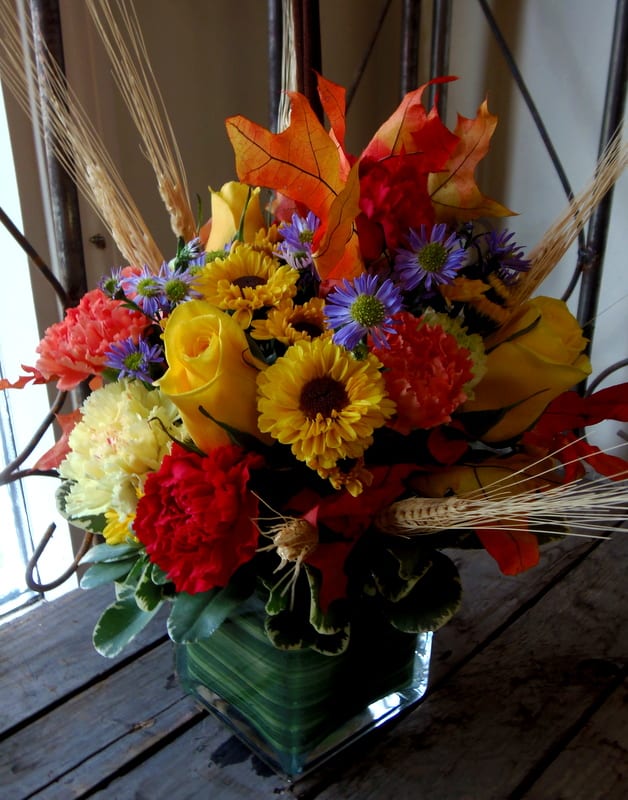 Chic Fall Cube #cfcc6 - A simple glass cube is filled with a chic assortment of blooms in classic autumnal hues. Roses,  and mums  are offset by a fall leave and wheat  add an extra touch of seasonal flair! due to popularity mums  and colors or the carnations may vary a bit from what is shown but will still be in fall tones