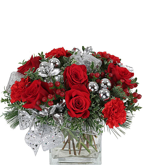  Visions of Sugarplums Arrangement  - Our original Visions of Sugarplums arrangement evokes the excitement felt the night before Christmas. A pretty clear cube vase featuring red roses, red carnations, hypericum berries, holiday greenery, silver balls and a silver bow. The perfect gift for this holiday season!
