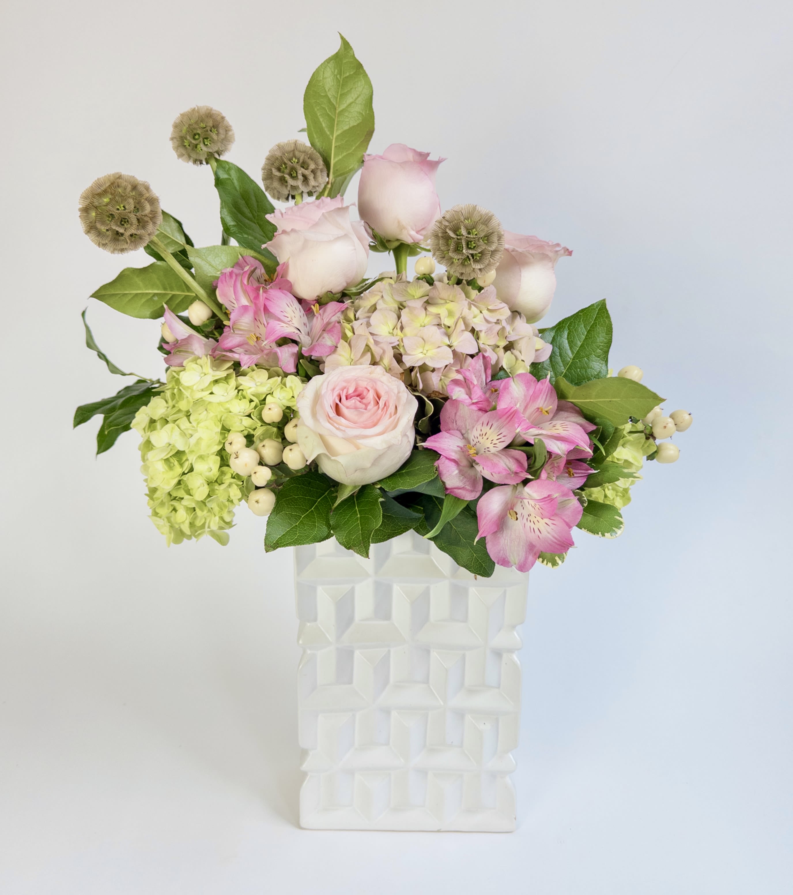 Mary Carolyn  - A fun white ceramic modern vase filled with pink and green hydrangeas, pink roses, pink alstroemeria and scabiosa pods. 