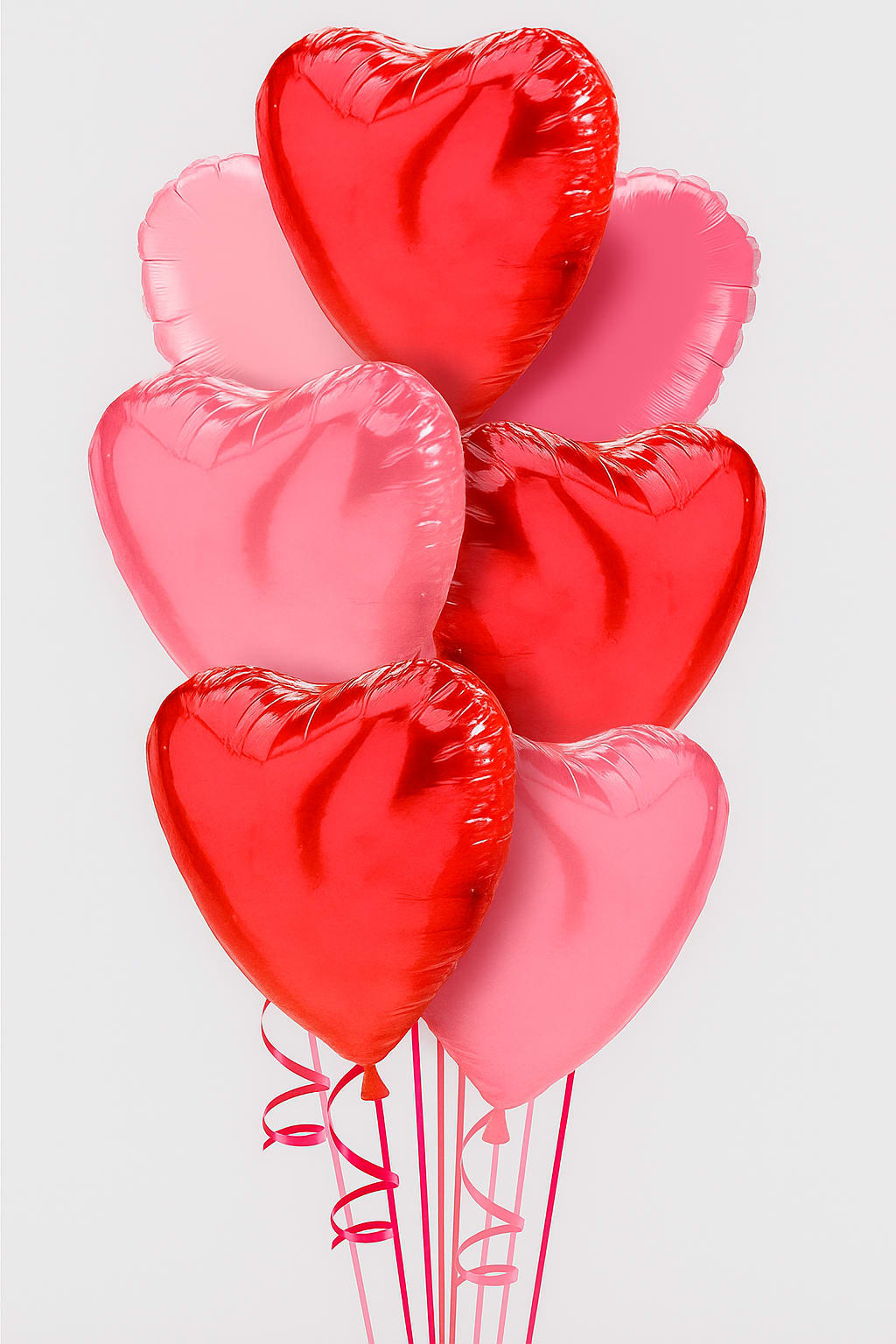 Red/Pink Hearts Arrangement - A vibrant bouquet of seven heart-shaped foil balloons in red and pink tones, featuring a glossy finish and curly matching ribbons — perfect for romantic celebrations, anniversaries, or Valentine’s Day decor.