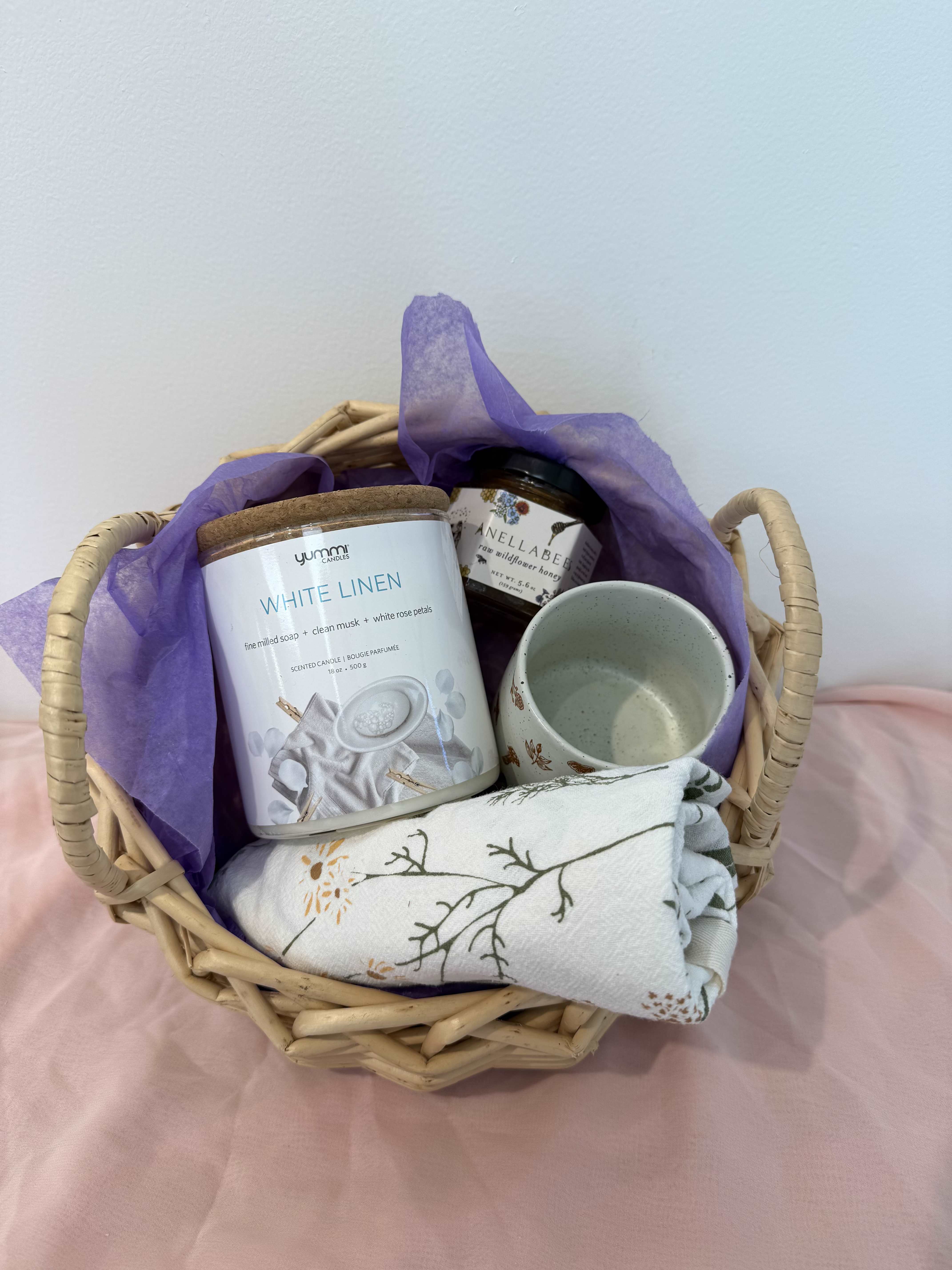 The Feel Better Bundle Gift Basket  - A gentle pick-me-up for anyone who needs a little extra comfort. This sweet set includes a whimsical mushroom mug for warm sips, golden honey to soothe, a herb - printed kitchen towel2 and a calming white linen candle to bring peaceful vibes. The perfect bundle of cozy care to lift the spirits and warm the heart.   Gift Basket includes:  1 Artsy Em - Mushroom Mug  1 Anellabees Honey  1 June &amp; December herb kitchen towel  1 Yummi White Line Candle | Fine milled soap, clean musk, white rose petals. plant based wax. 18oz