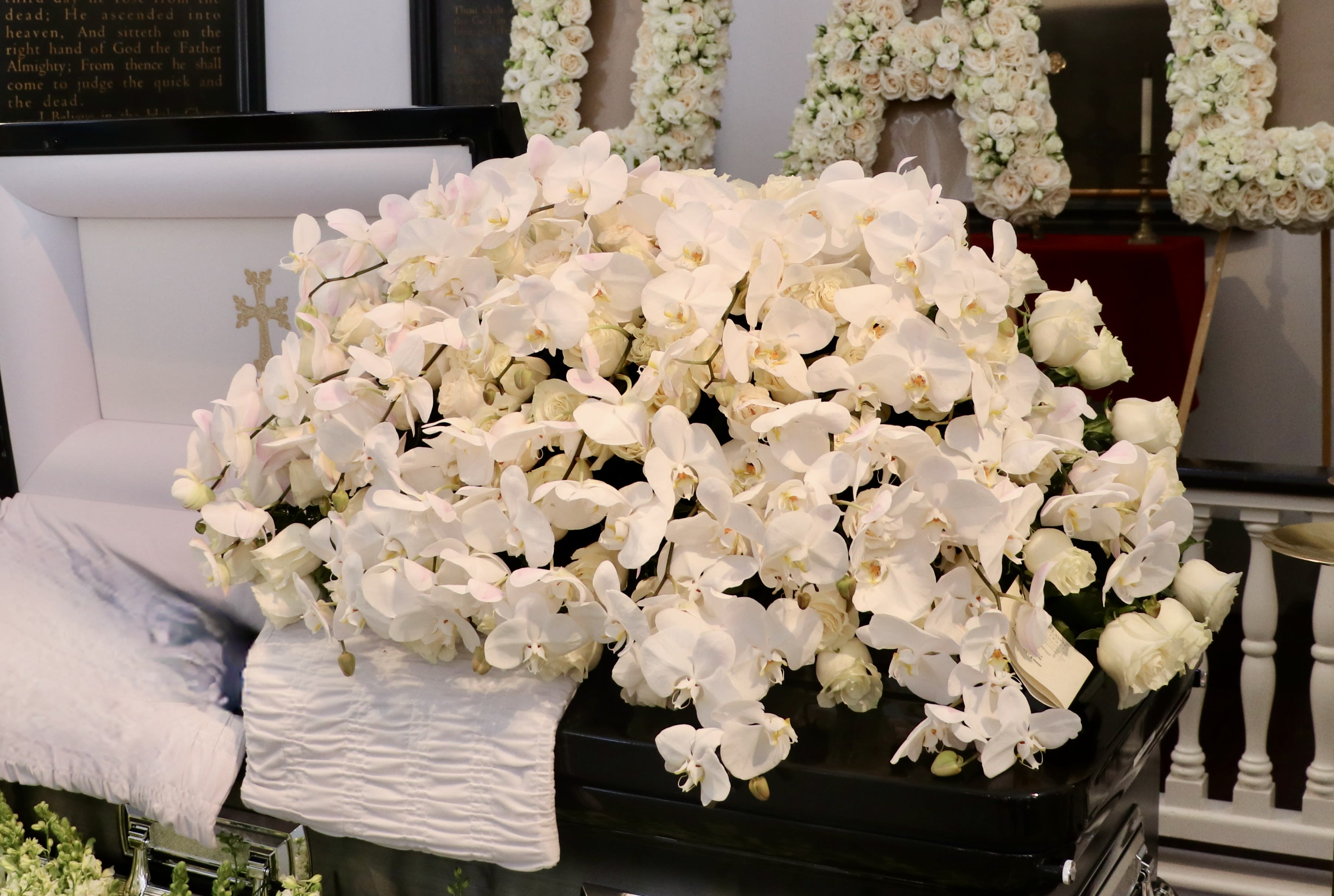 White Rose and Orchid Casket Spray - This casket display is made with premium white roses and beautiful cascading orchids.    Standard size is half casket, deluxe is 3/4 and premium is full casket.