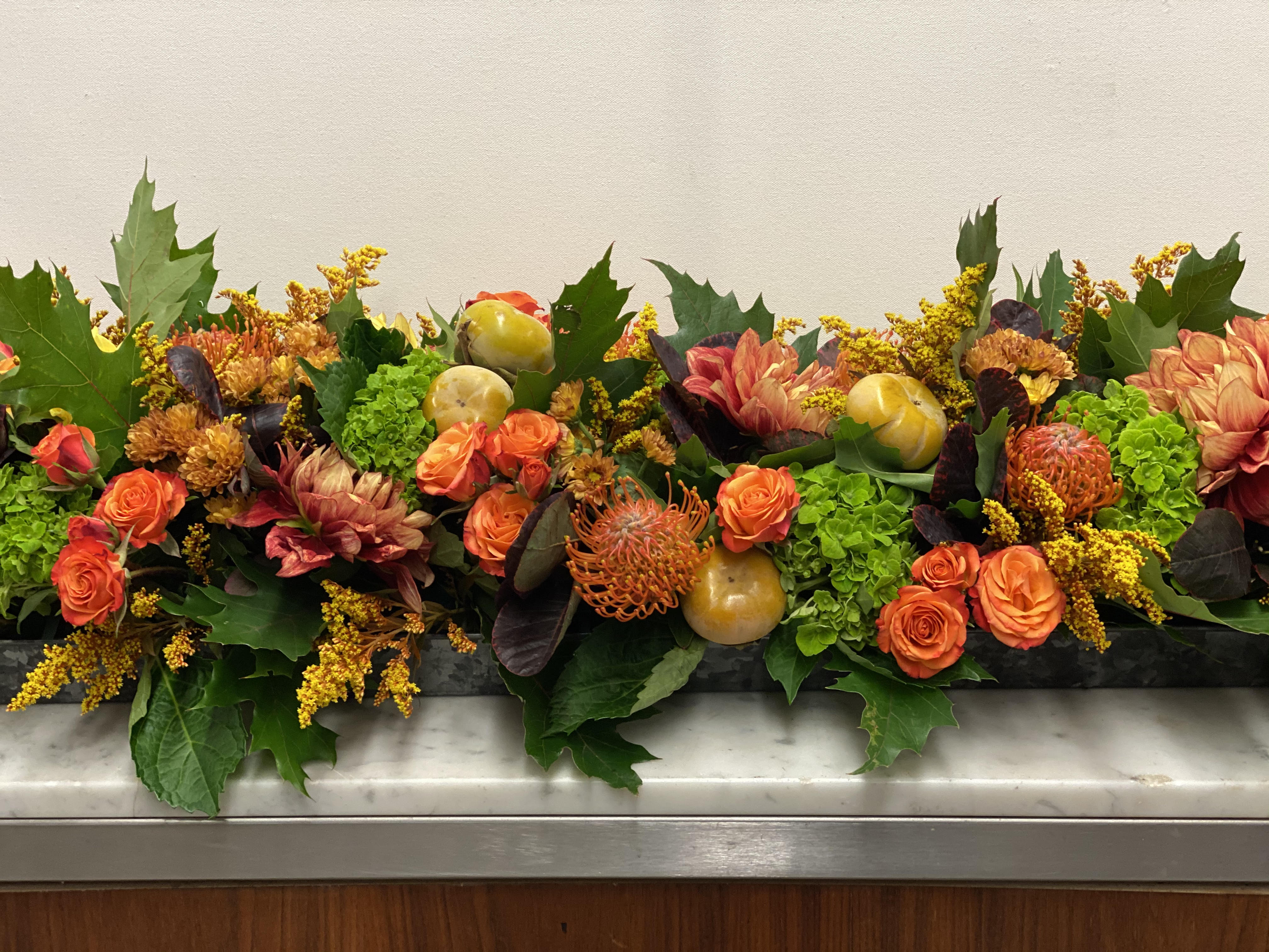 Rectangular Harvest Centerpiece - A long tray in fall harvest textures including oak leaves, roses, orchid blooms and the best abundance of the season. Small Tray: 4X6&quot; tray/ Arrangement approximately 12&quot; long X 8&quot; wide  Large tray available as an upgrade 4X10&quot; tray/ Arrangement approximately 16&quot; long X 8 &quot; wide 