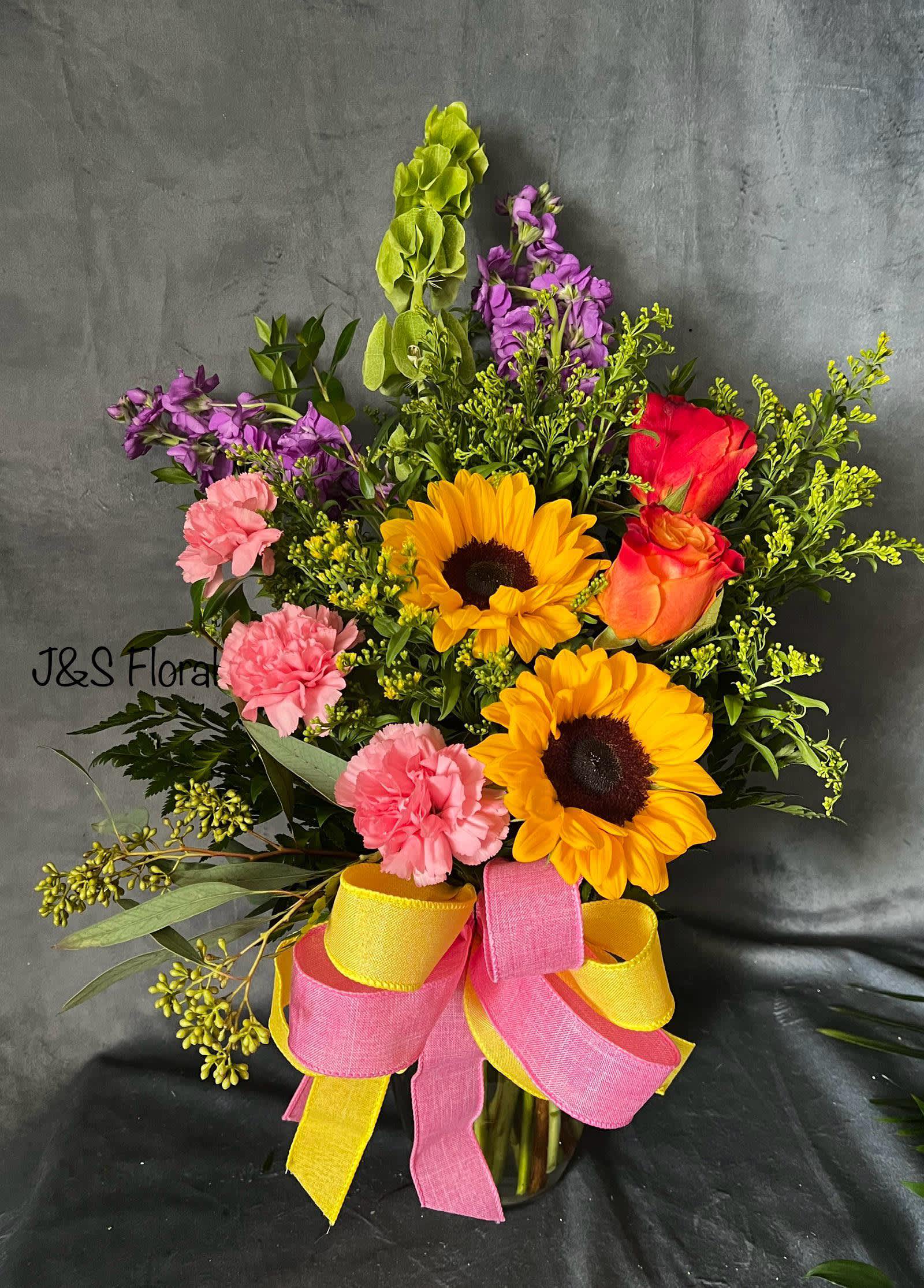 Summer Blooms - Introducing Our New Design Summer Blooms, beautifully arranged with bright colorful flowers, sunflowers, pink carnation, purple stock, orange roses, fillers and greenery  The size shown is the standard size