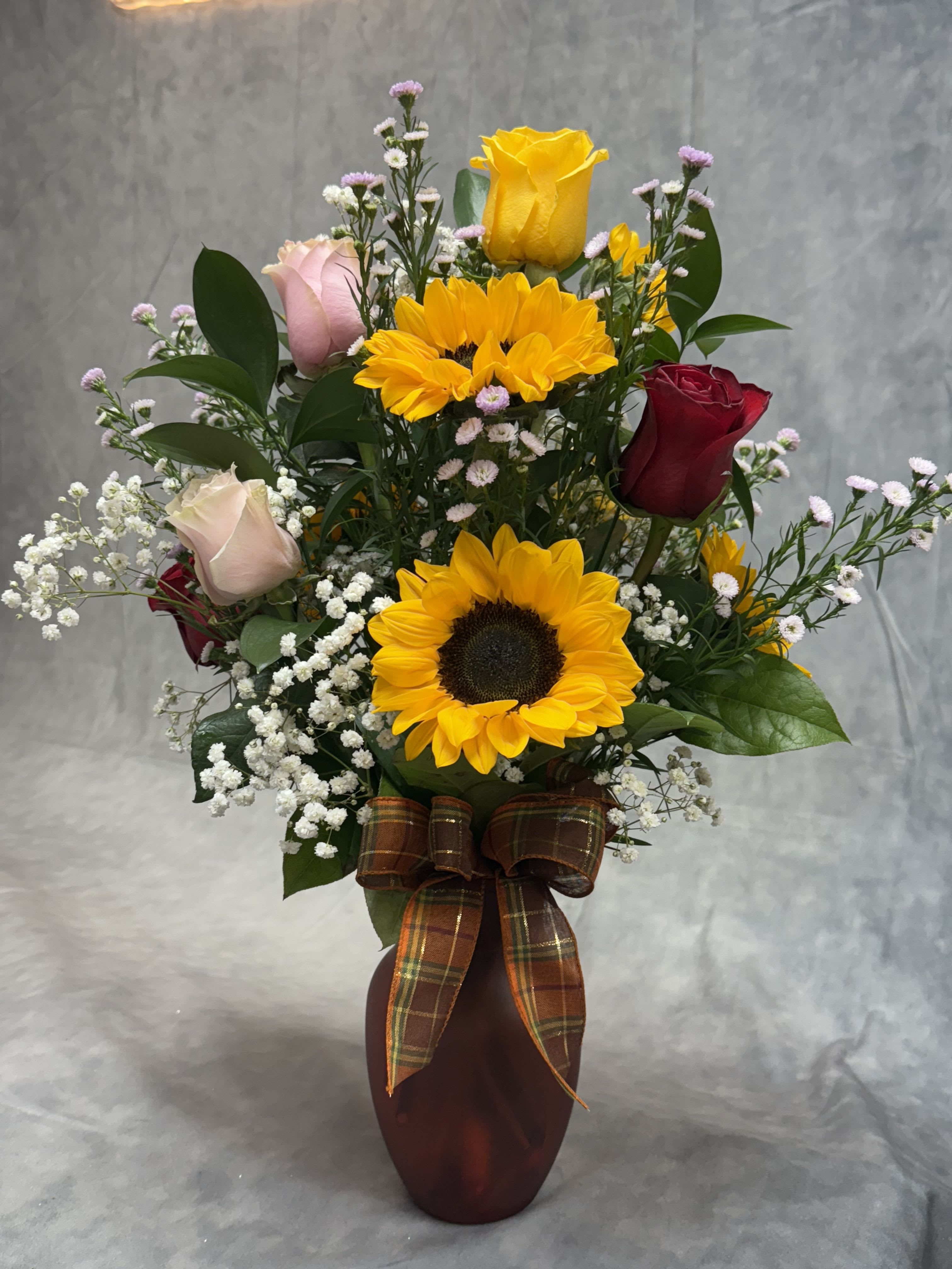 Sunshine and Roses  - Introducing our vibrant sunflower and rose vase, a perfect blend of warmth and beauty. The cheerful sunflowers bring a burst of sunshine, while the elegant roses add a touch of romance. Ideal for any occasion, this lively arrangement brightens up any space and spreads joy!  