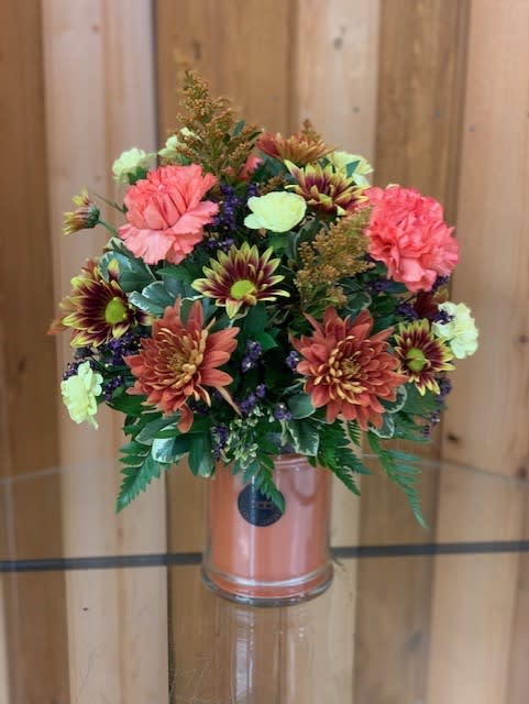 Candle Flower Arrangement - seasonal flowers  - Engraved Large Jar Candle with Optional Floral Arrangement – Haehn Florist &amp; Greenhouses  Send a unique gift that smells as wonderful as it looks! This large engraved jar candle is the perfect keepsake, burning for 145+ hours to fill any space with warmth and fragrance. Personalize your candle with a name, message, or special design—making it a one-of-a-kind gift for birthdays, anniversaries, memorials, or “just because.”  Please email the details you’d like engraved to haehnfloristlaser@gmail.com. Note: all engraving is completed before adding a flower arrangement.    Upgrade option: Choose the premium arrangement to have your candle beautifully displayed in a lush bed of fresh flowers—and this option includes a decorative lid. Standard engraved candles do not include a lid.   Available at: Haehn Florist &amp; Greenhouses 410 Hamilton Rd. Wapakoneta, OH 45895 ️ 419-738-8485  Give a gift that lasts long after the flowers fade—a fragrant, personalized candle that’s sure to be cherished.