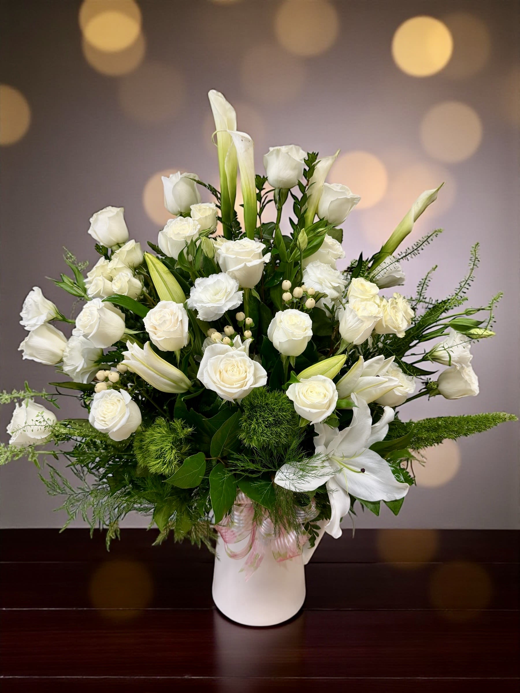 Puré Love - A timeless blend of roses, lilies, and fresh greenery — perfect to honor a beautiful life or brighten a special moment with grace and serenity.