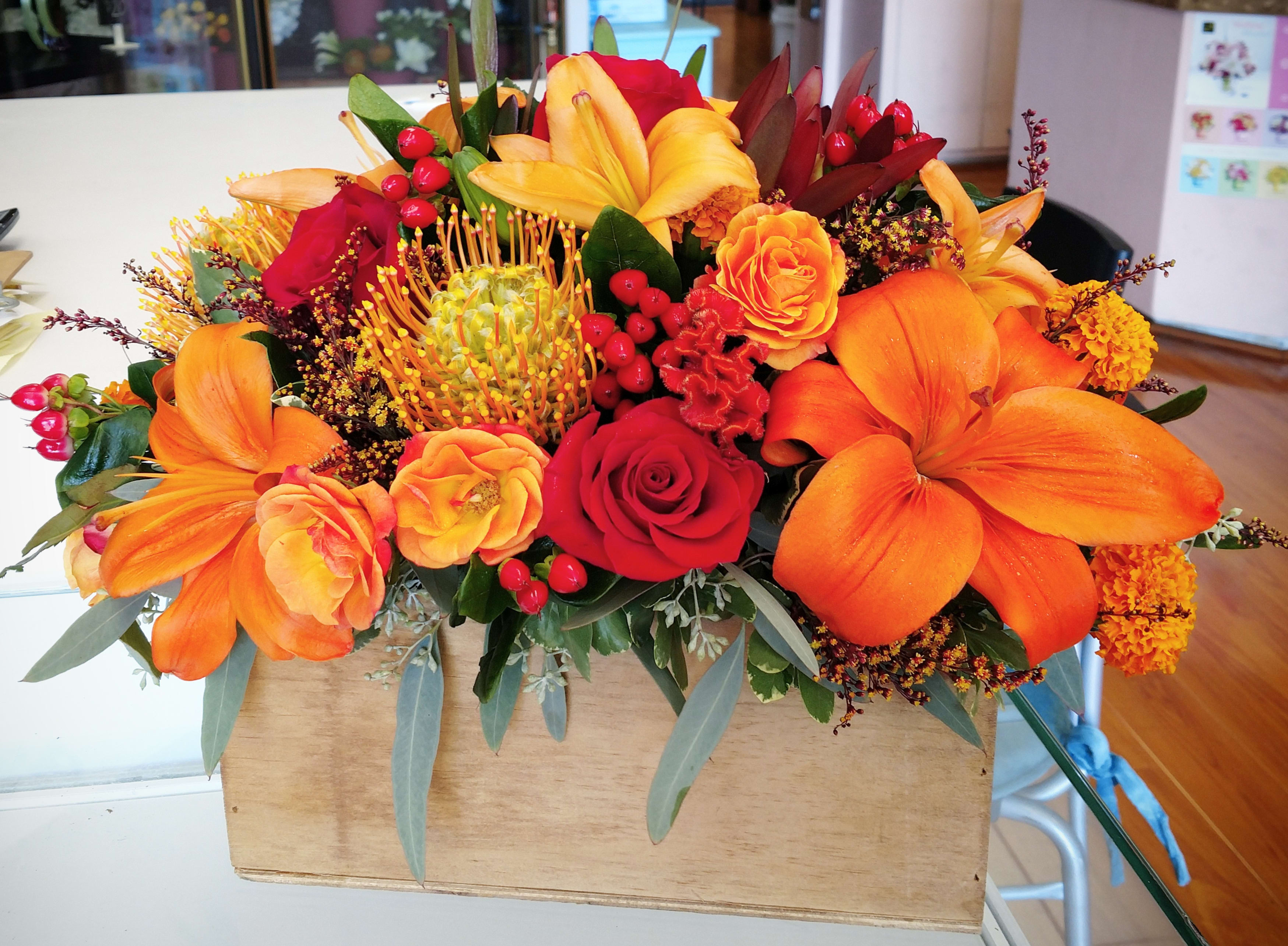 Fall Designers Choice Centerpiece Arrangement - Introducing this fall festive holiday piece. Whoever you’re sending this to will smile with joy upon receiving this abundant box of seasonal blooms. Each order will differ depending on the season's blooms that are available at that time. Size is 19&quot; in length and 11&quot; tall