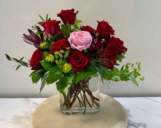 The One - A breathtaking arrangement that speaks of love, devotion, and individuality. Eleven deep red roses symbolize passion and timeless romance, while a single pink rose stands apart, representing that one extraordinary person who captures your heart. Designed in a sleek modern vase, The One is a statement of admiration for someone truly unique.