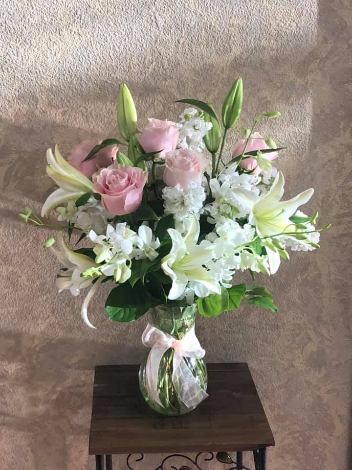 Whispering Angel - Type of Flowers: Lilies, Roses, Stock, Dendrobium orchids in a short vase with ribbon. Availability: All year round Substitute Available: Yes Design View: Symmetric Front Facing View Photo shown: Regular 