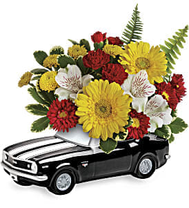 '67 Chevy Camaro Bouquet - This colorful arrangement includes miniature yellow gerberas, white alstroemeria, red miniature carnations, red matsumoto asters, yellow button spray chrysanthemums, variegated pittosporum and sword fern. Delivered in a '67 Chevy Camaro keepsake. Approximately 12&quot; W x 10 1/4&quot; H 