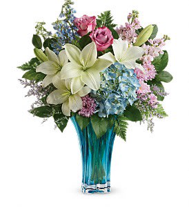 Heart's Pirouette Bouquet - This arrangement features blue hydrangea, lavender roses, white asiatic lilies, light blue delphinium,  lavender cushion spray chrysanthemums, misty blue limonium, leatherleaf fern, and lemon leaf. Delivered in a Heart's Pirouette vase. Approximately 19 1/2&quot; W x 23&quot; H 