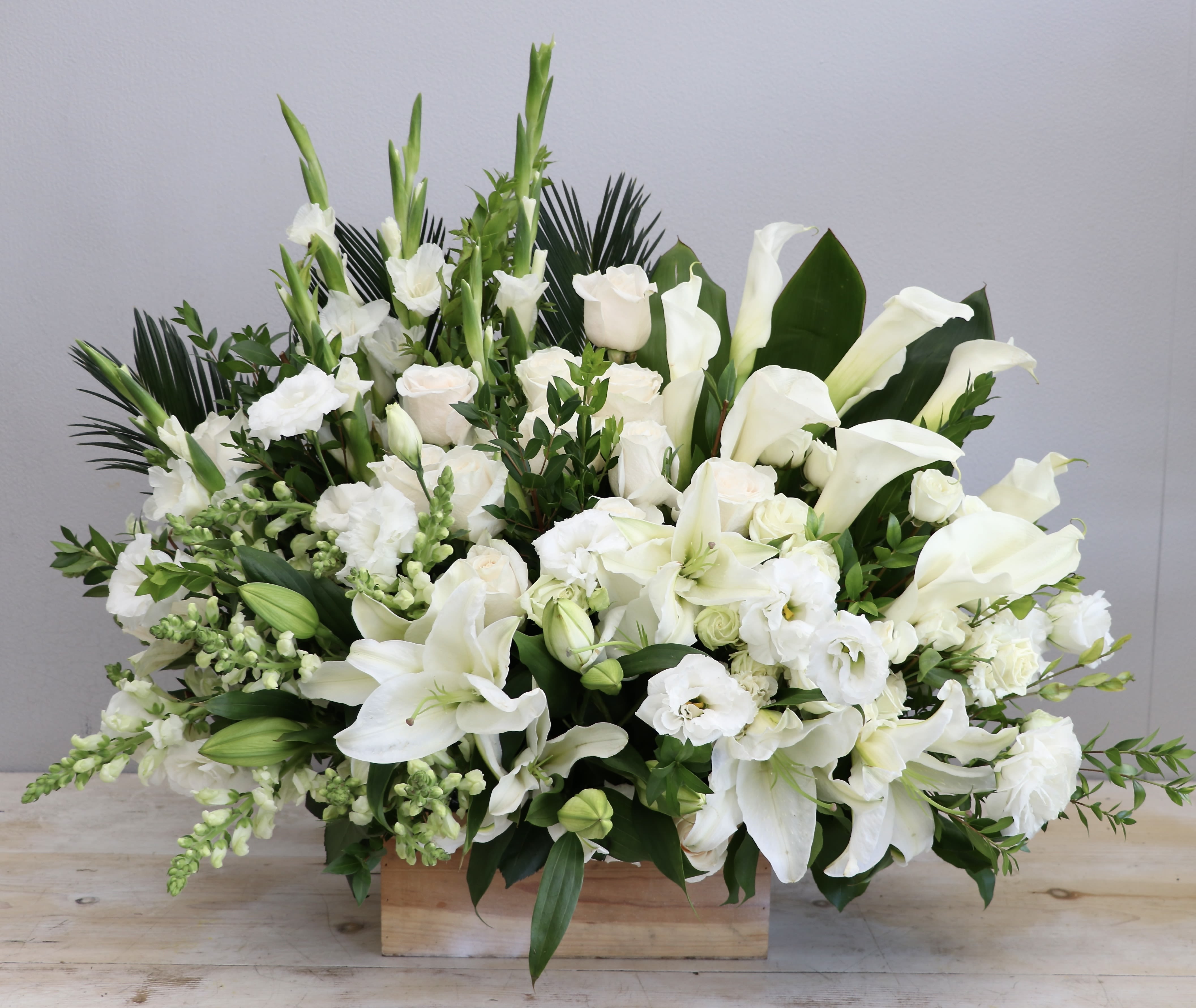 All White Box   - This sympathy arrangement contains a perfect mix of lilies, roses, snap dragons and seasonal greens.
