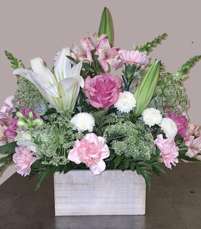 Blushing Blooms - White washed wood container with white lily, lavender roses, snap dragons and queen Ann’s lace.