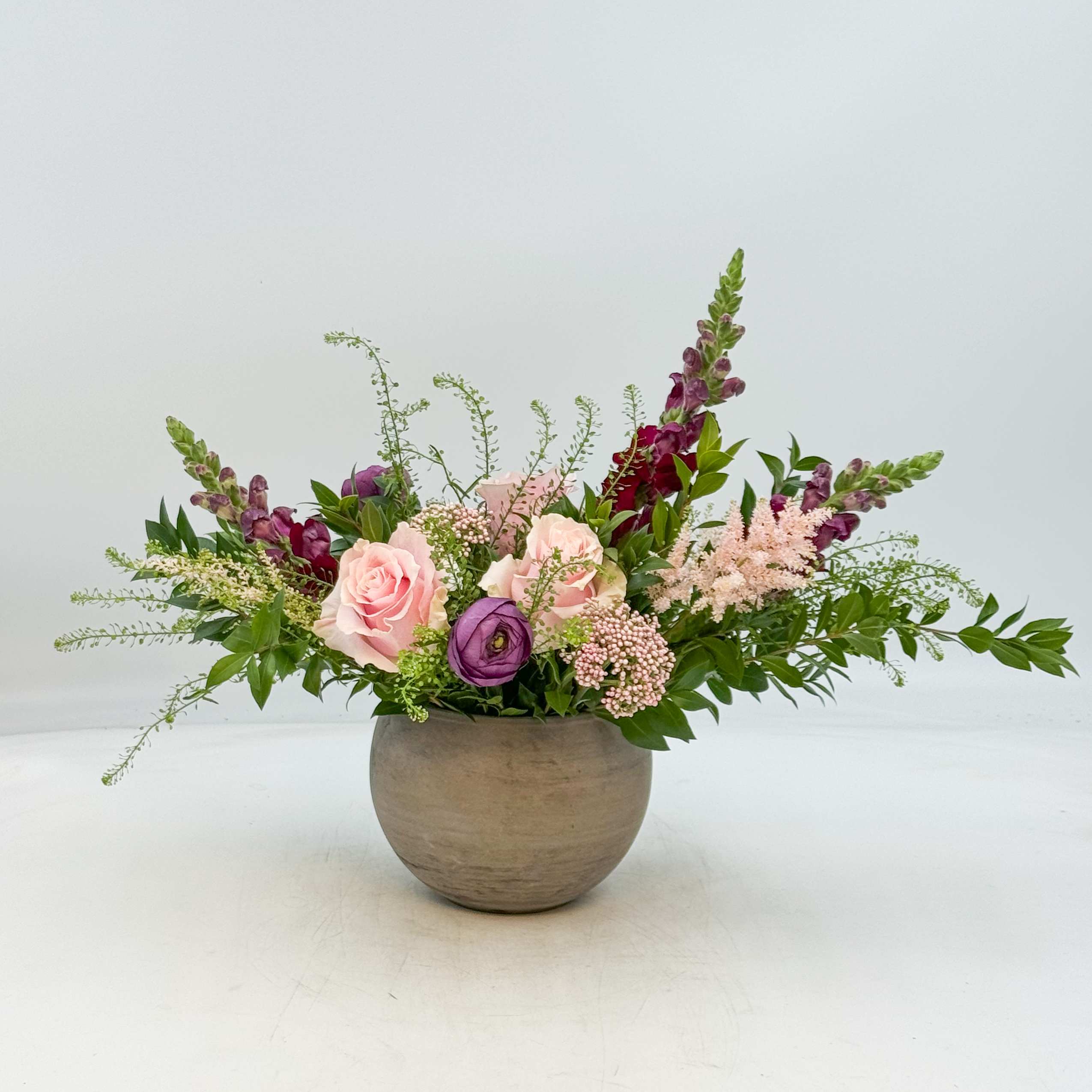 Provence - Provence is a whimsical plum and blush design featuring Purple Snapdragon, Purple Ranunculus, Pink Astilbe, Pink Mondial Roses, Pink Riceflower, Myrtle and Lepidium. The Standard, Deluxe and Premium Provence is arranged in a 5 inch ceramic planter.
