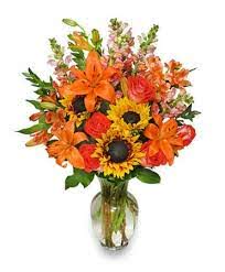Fall Flower Jamboree - Delightful fall mix with orange lilies, sunflowers, snap dragons, orange roses and fall inspired fillers. Our fall jamboree brings joy and warmth to any room for any event or occasion. 