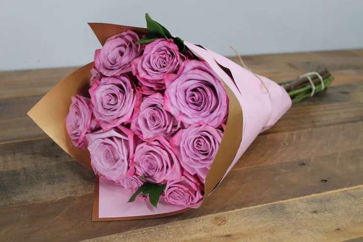 Amour in Bloom - Elegant arrangement of a dozen exquisite purple roses, beautifully presented in waterproof floral wrap to ensure lasting freshness.