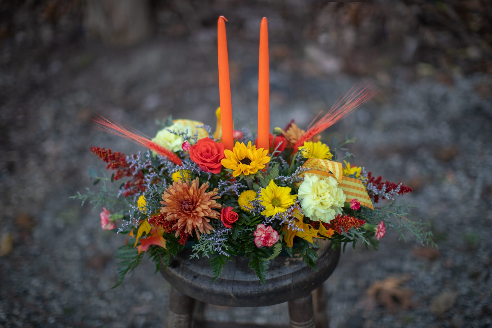 Give Thanks Centerpiece 2 Candle - Perfect centerpiece for your family's dinner table this Thanksgiving! Long burning taper candles bring the ambiance of harvest. We are happy to join the festivities with flowers.