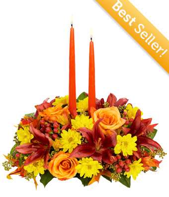 Thanksgiving Moments centerpiece - Cherish new memories you will make this year with family and friends, gathered around this beautiful Thanksgiving Centerpiece. A beautiful designer-inspired seasonal dish container complemented by orange taper candles is the stage for gorgeous orange roses, red lilies, yellow daisy poms, red hypericum and eucalyptus.