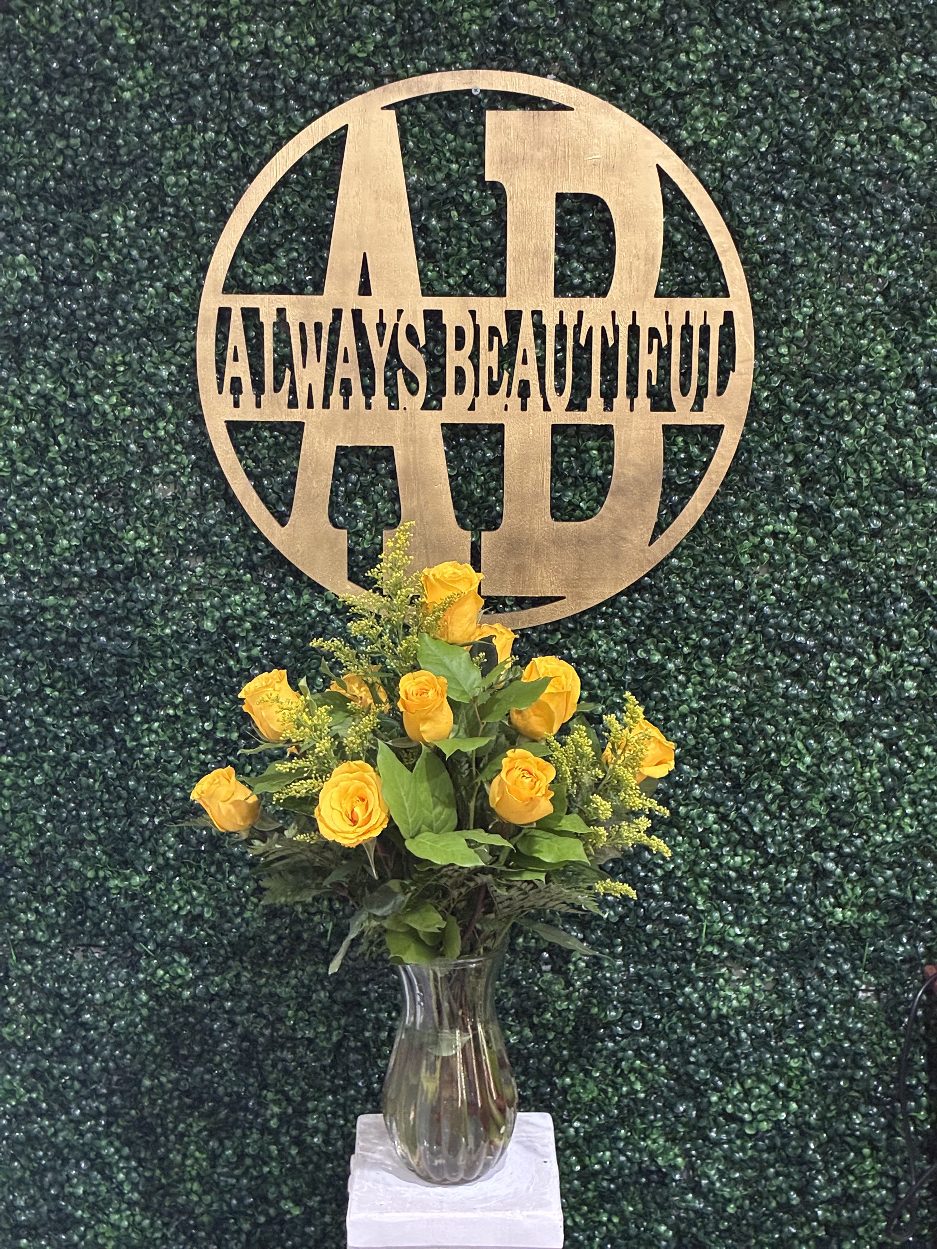 Dozen Long Stem Yellow Roses - Radiating warmth, cheer, and happiness, our Dozen Yellow Roses are the perfect way to brighten someone’s day. These golden-hued blooms symbolize friendship, joy, and new beginnings—making them an ideal gift for birthdays, congratulations, get-well wishes, or “just because” moments. Expertly arranged with lush greenery and yellow solidago for a touch of texture, this bouquet is presented in a classic clear glass vase for timeless elegance.  Whether you’re celebrating a milestone or simply spreading a little sunshine, this vibrant arrangement will deliver smiles every time.