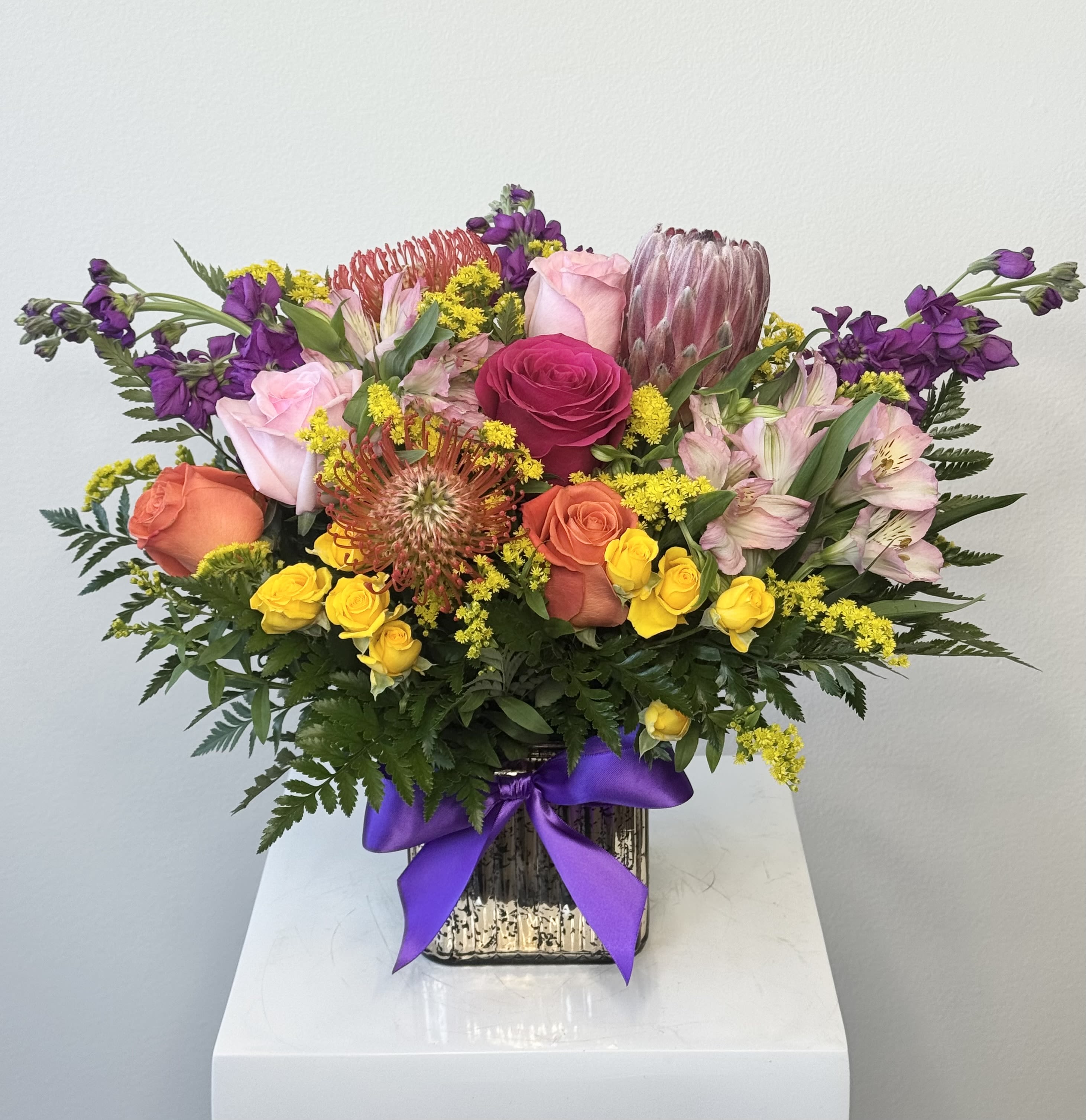 Sunny Delight - Sunny Delight: a bright design made with warm colors to embolden your heart, enrichen your home and enhance your day. Main colors: pink, white, orange, yellow. Typically includes: Pink Ice Protea, Pincushion Protea, Orange Roses, Yellow Roses, Pink Roses, Orange Spray Roses. Subject to substitution.