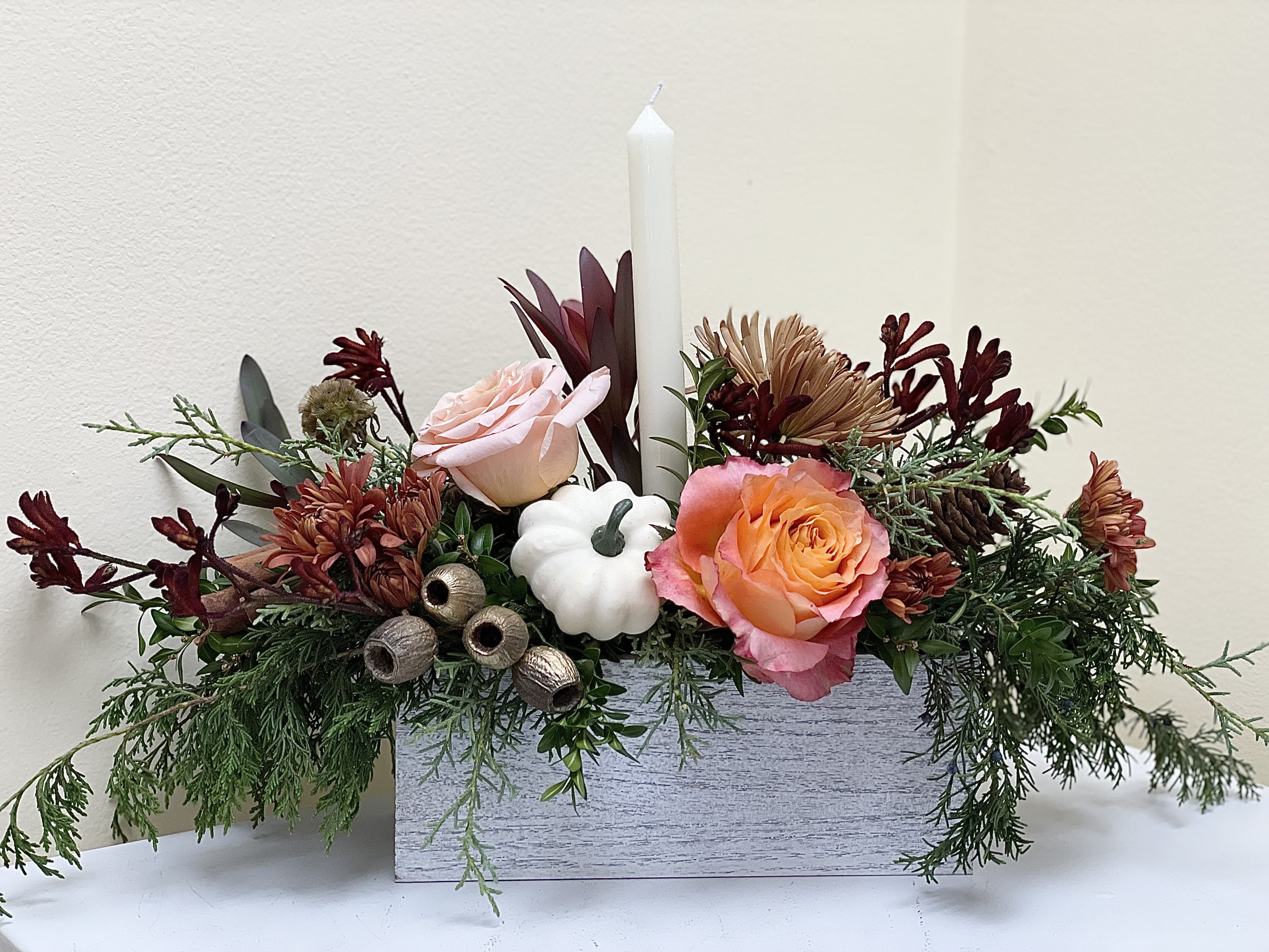 Autumn Splendor - A lovely fall centerpiece designed especially for the Thanksgiving season, variety of greens and gorgeous fall blooms. The flowers might be different but the design will reflect the picture. Textural elements includ pods and cinnamon sticks.