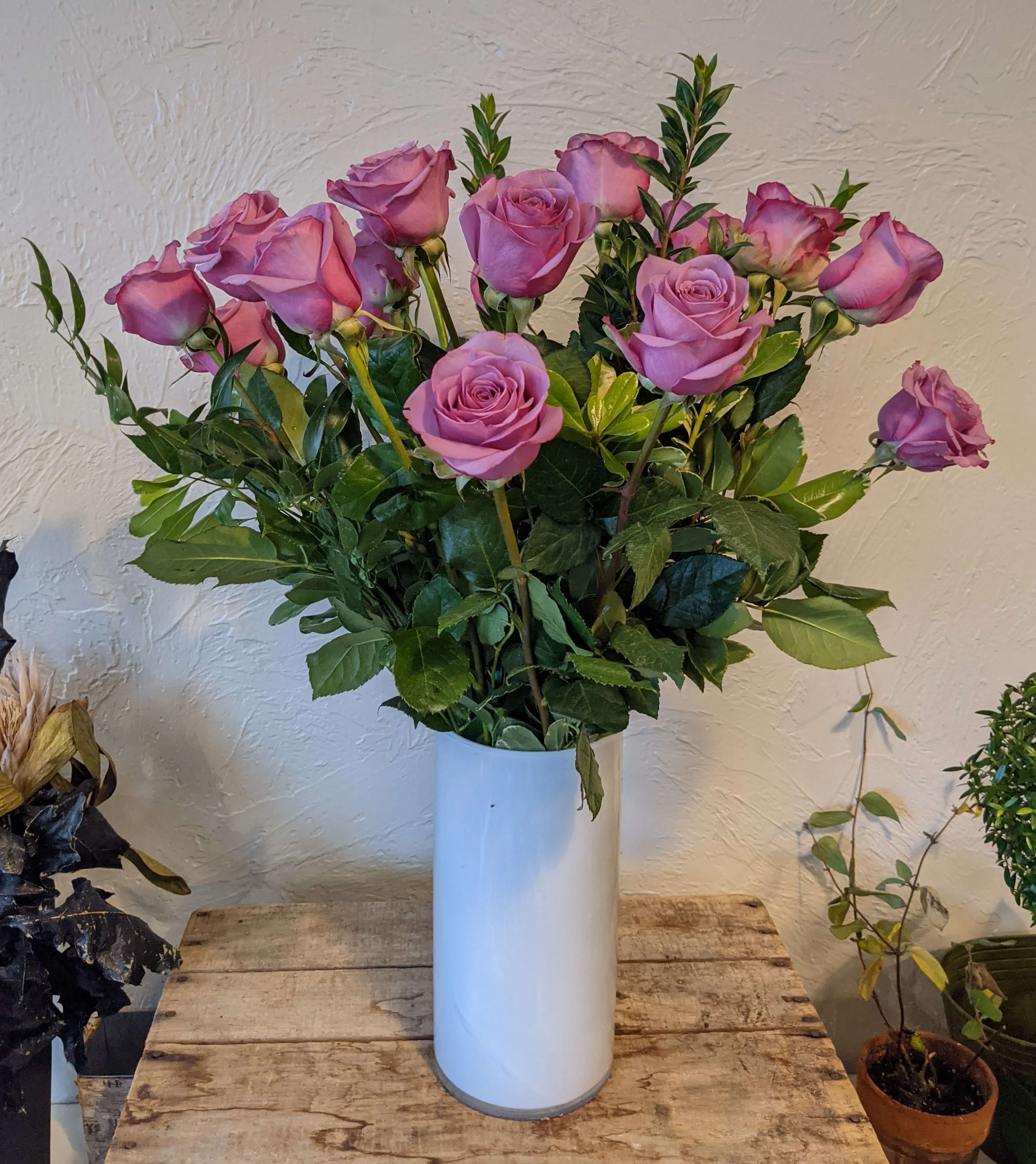 Lavender Roses in a Vase - A timeless classic, send a dozen roses in a vase with complementing greenery. Also available in a dozen and a half and two dozen options, just select Deluxe or Premium respectively.