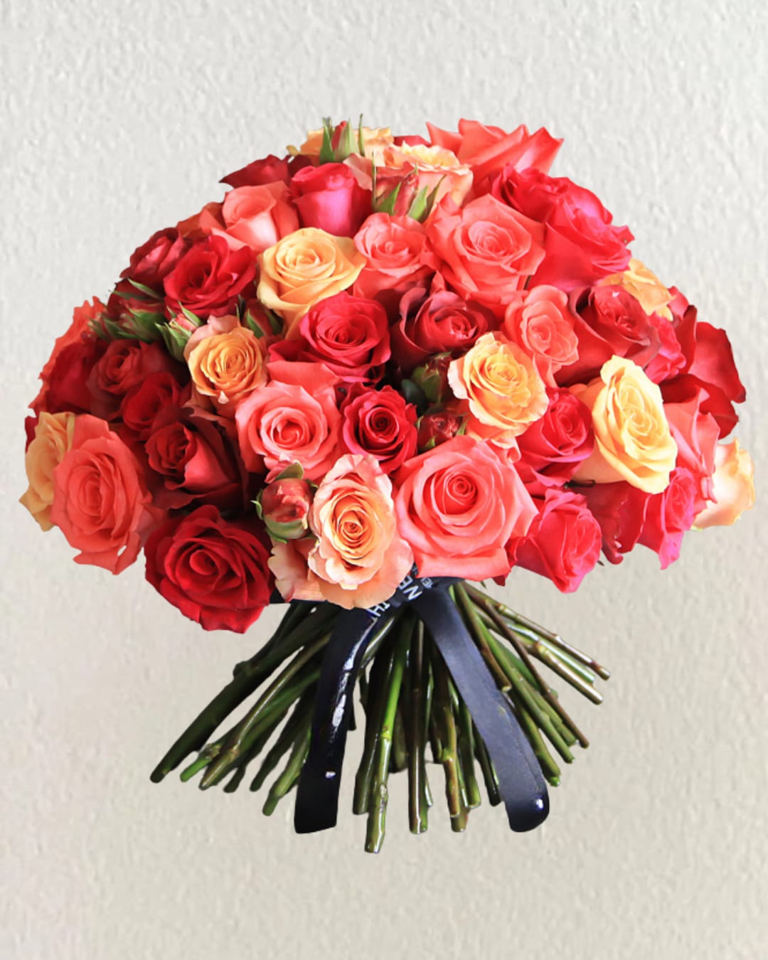 Snset Rose Bouquet - Warm and radiant, the Sunset Rose Bouquet is a bold expression of love and joy. With its rich gradient of coral, orange, and deep red roses, it’s perfect for celebrations, anniversaries, or romantic gestures that leave a lasting impression.  (Flowers may vary based on seasonal availability.) 