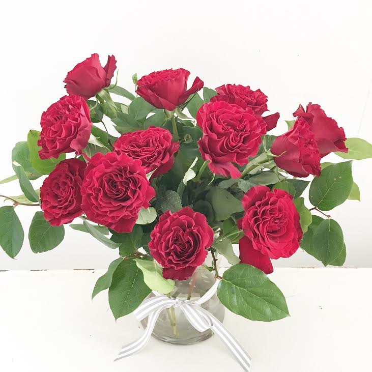 A Dozen Red Garden Roses  - A rose by any other name is a timeless classic. Our lush, deep-red garden roses are hand-delivered in a simple clear vase, with your heartfelt message tucked into our signature white satin ribbon.  ***Roses available in other colors, subject to daily availability. Please call to inquire.*** 