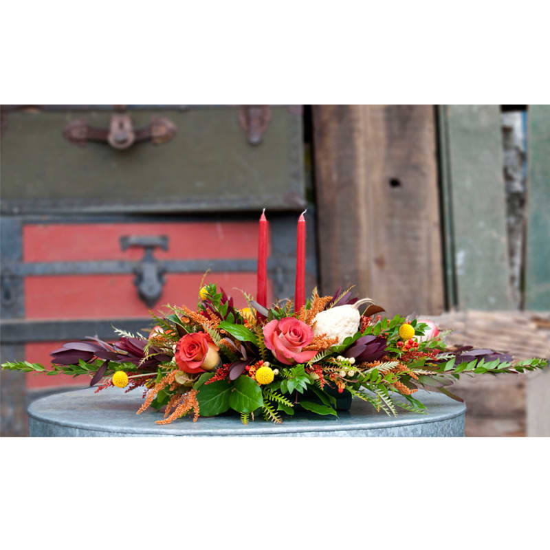 Autumn Candle Centerpiece - A Farm Fresh mixture of autumn toned flowers accented with fall gords and mini pumpkins complete with a autumn taper candle.    Regular Arrangement features a single candle  Deluxe Arrangement features two taper candles  Premium Arrangement Features 3 taper candles