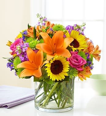 Floral Embrace - Like a warm embrace, our vibrant bouquet delivers your sentiments to someone special. A rich gathering of yellow and orange blooms, with pops of bright pink and purple, it's more than a gift - it's a way to express how you feel inside.