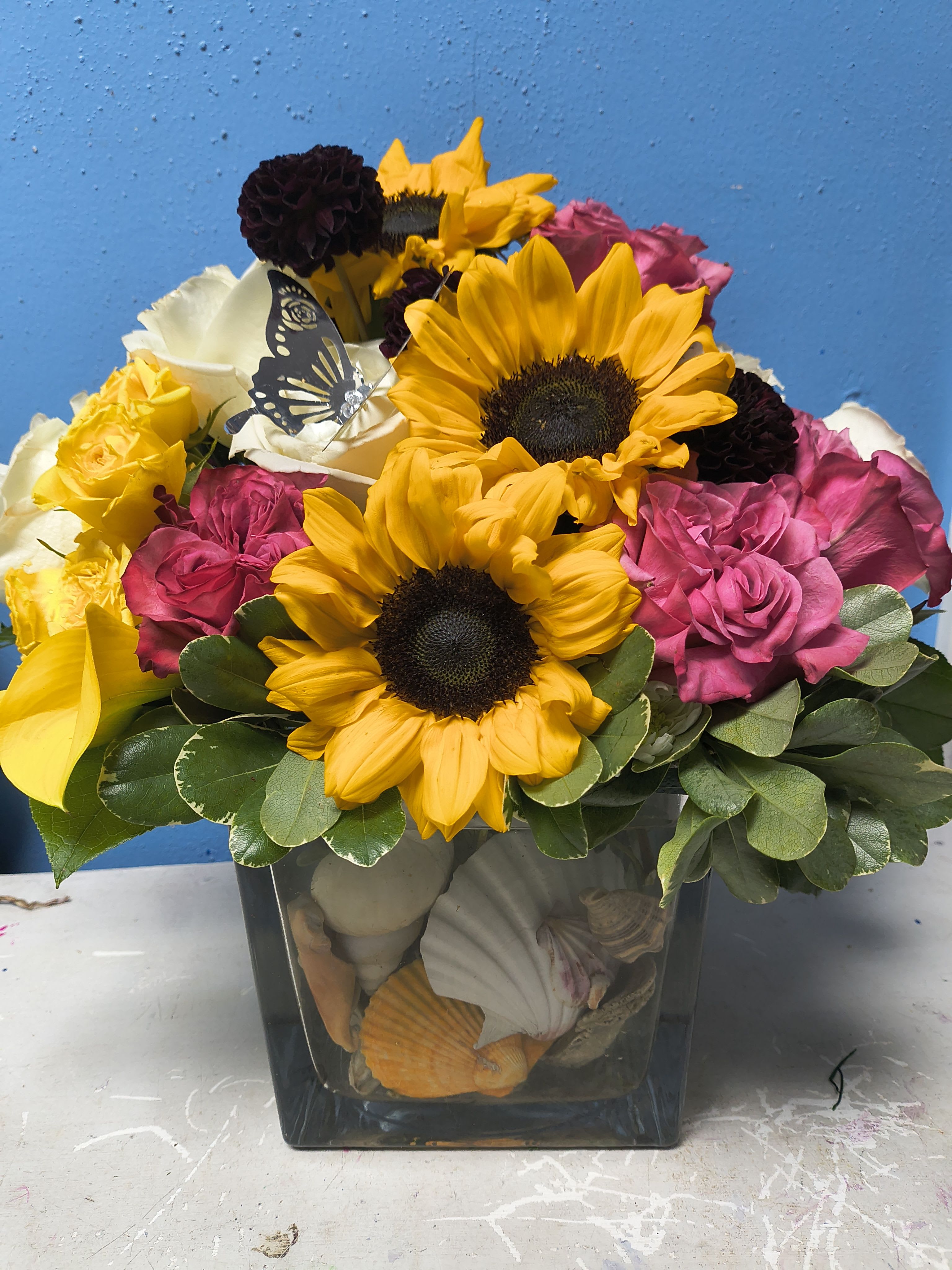 Mermaids Garden - Designed in a beautiful large glass cube vase filled with real seashells and designed with a an assortment of rich colors and premium flowers. A perfect gift for anytime of the year 