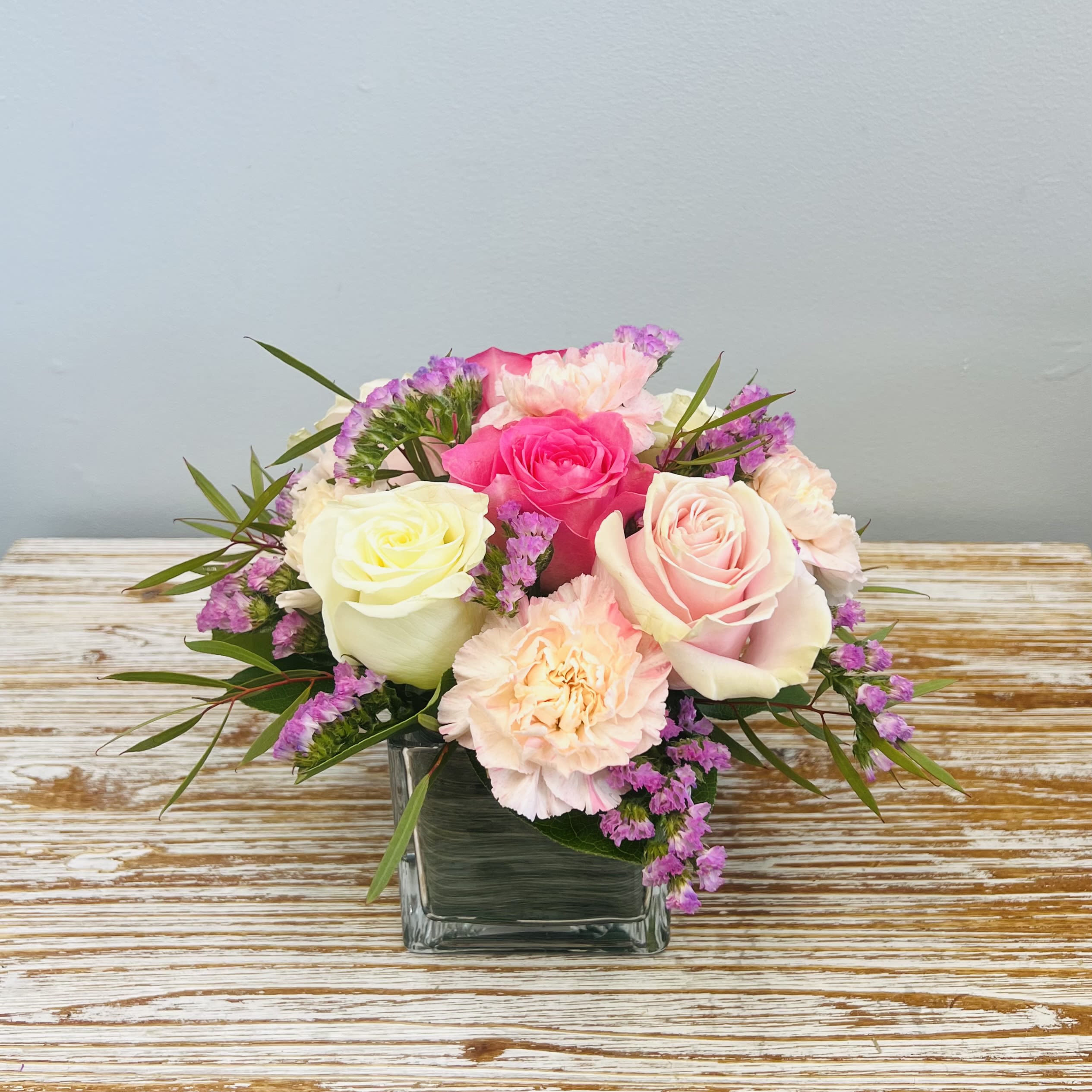 Blush Rosé - Our Blush Rosé arrangement has multiple shades of Pink blooms with a splash of White in a 4” Leaf Wrapped Glass Cube.  Approximately 10” Tall