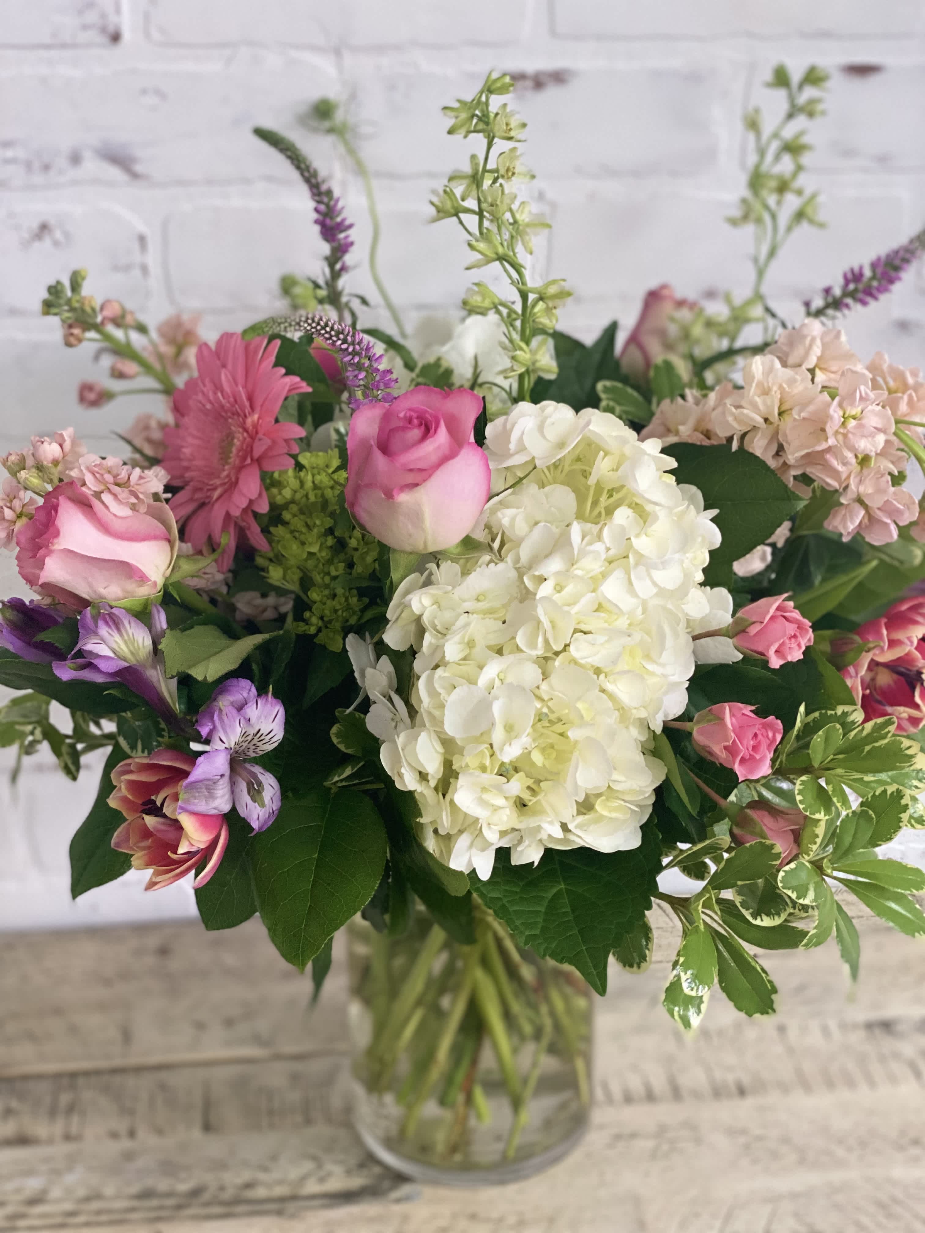 Hello Spring - Swing into spring with sweet spring colors. A mix of hydrangeas, tulips, gerbera daisies, larkspur, stock, tulips, any fresh seasonals.