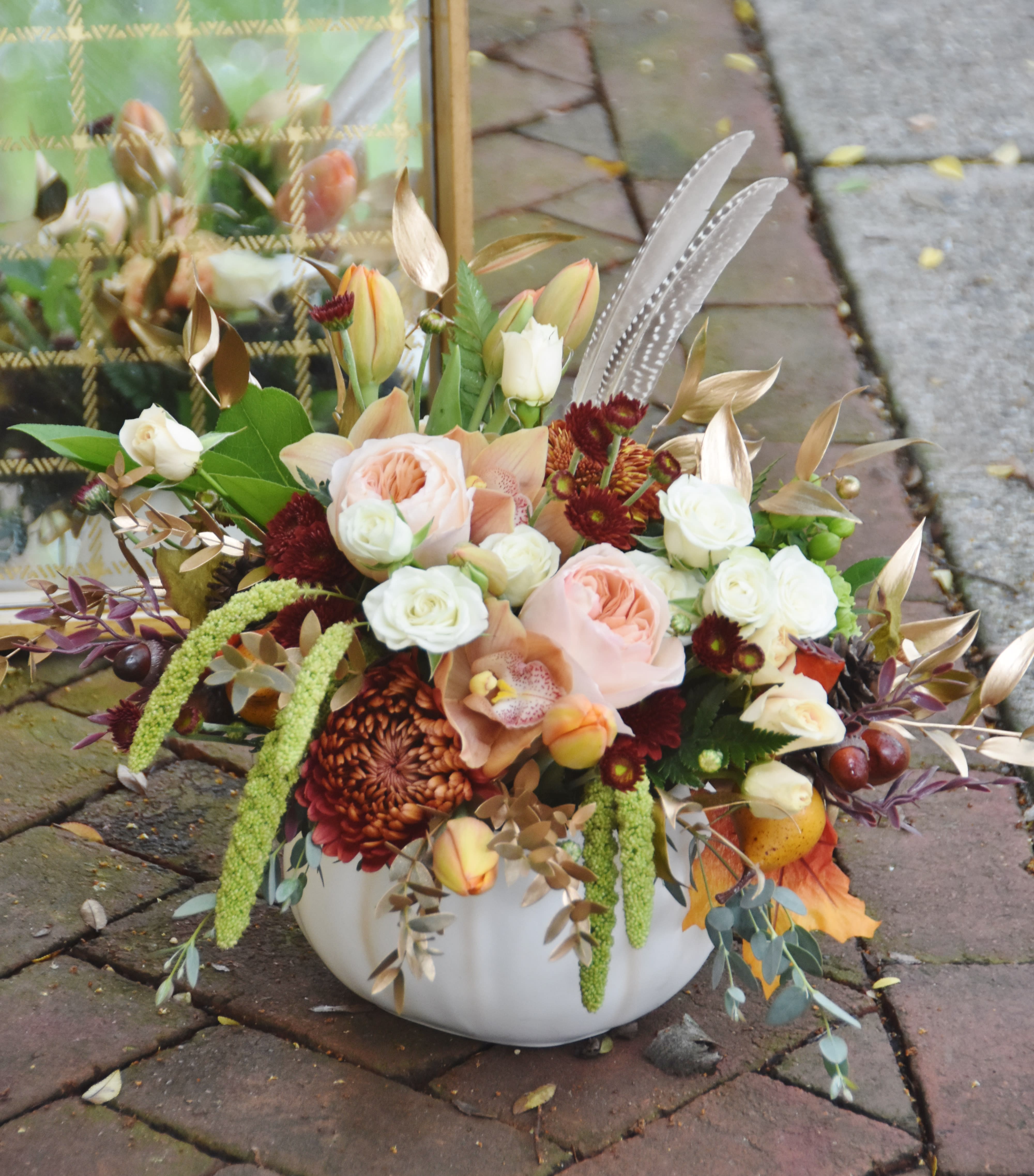 Autumn Delight - Gorgeous autumnal design with peach color Juliet garden roses, cymbidium orchids, accented with gilded gold foliage. Designed in a white ceramic pumpkin with a lid. Thoughtful gift for the season, or as a centerpiece as well.